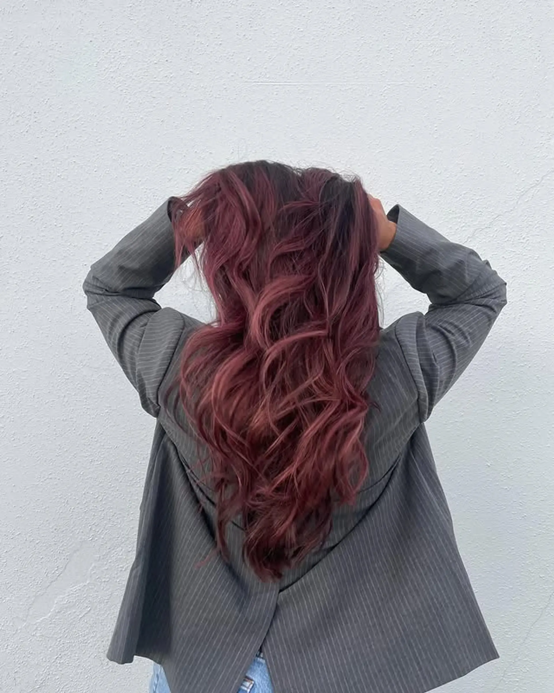 Long, wavy hair with a rich, mulberry red color achieved with balayage or ombre techniques. 1