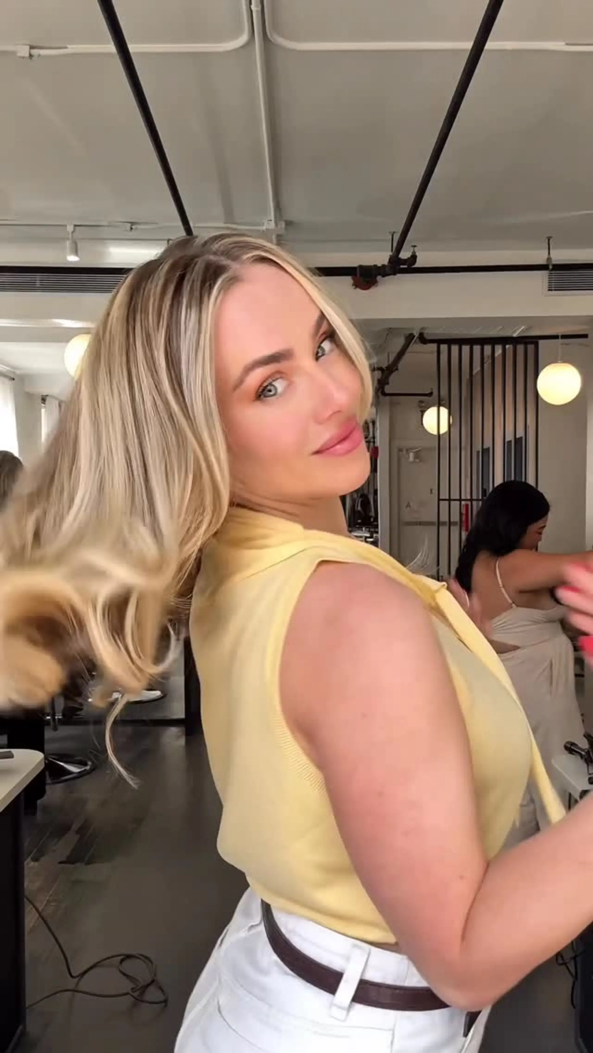 Medium-length icy blonde hair styled in a bouncy, layered blowout with soft flicked waves. 1