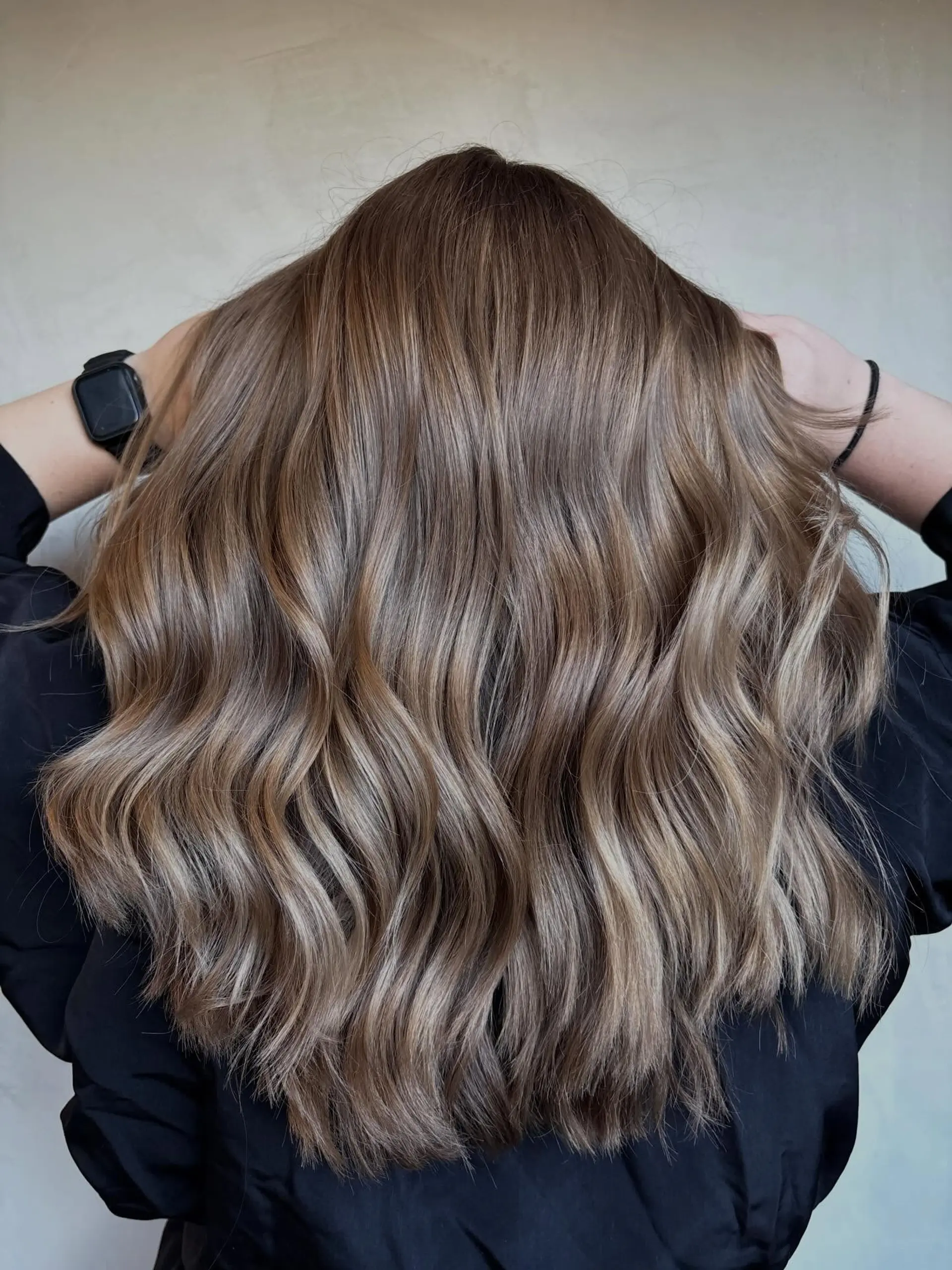 Cool-toned, dimensional ash brunette balayage styled in loose, lived-in waves. 1