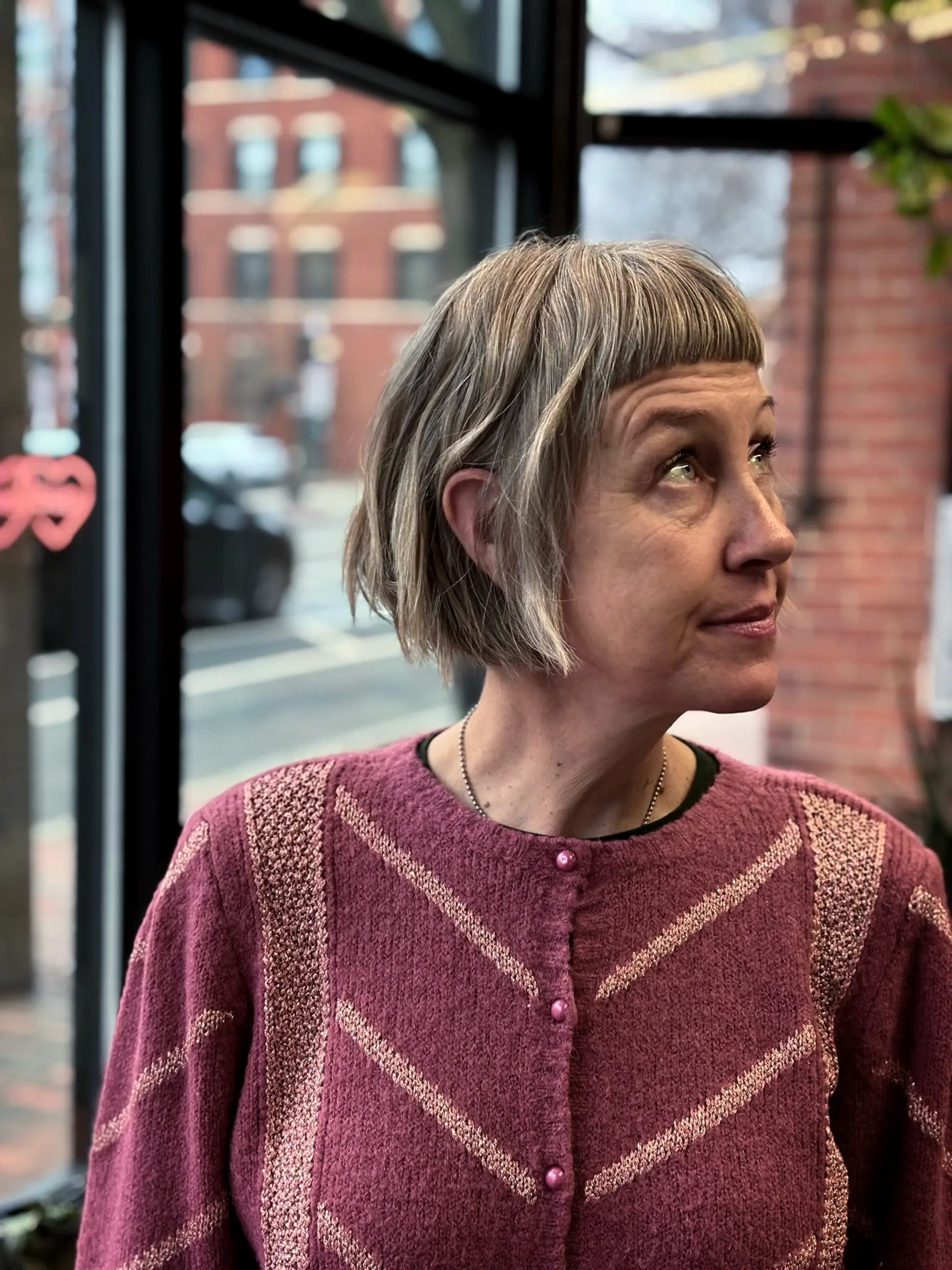 A textured short bob haircut featuring blunt micro bangs and soft natural movement. 1