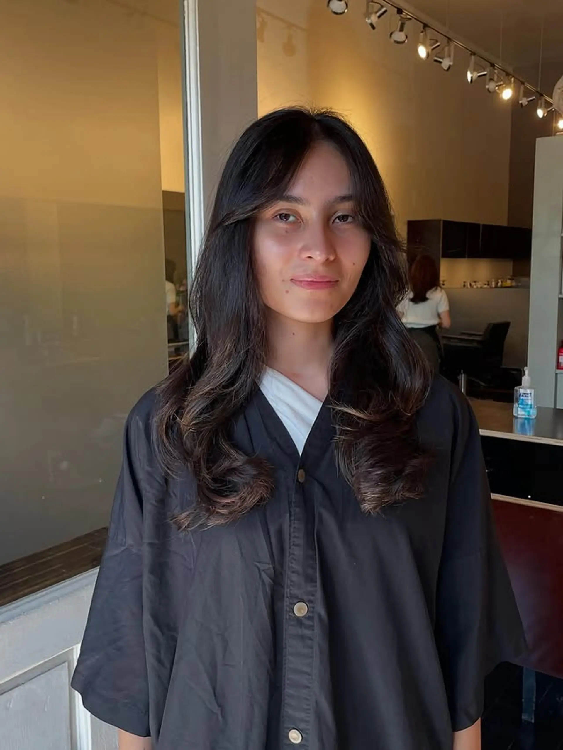 A long, wavy hairstyle with face-framing layers and curtain bangs. 1