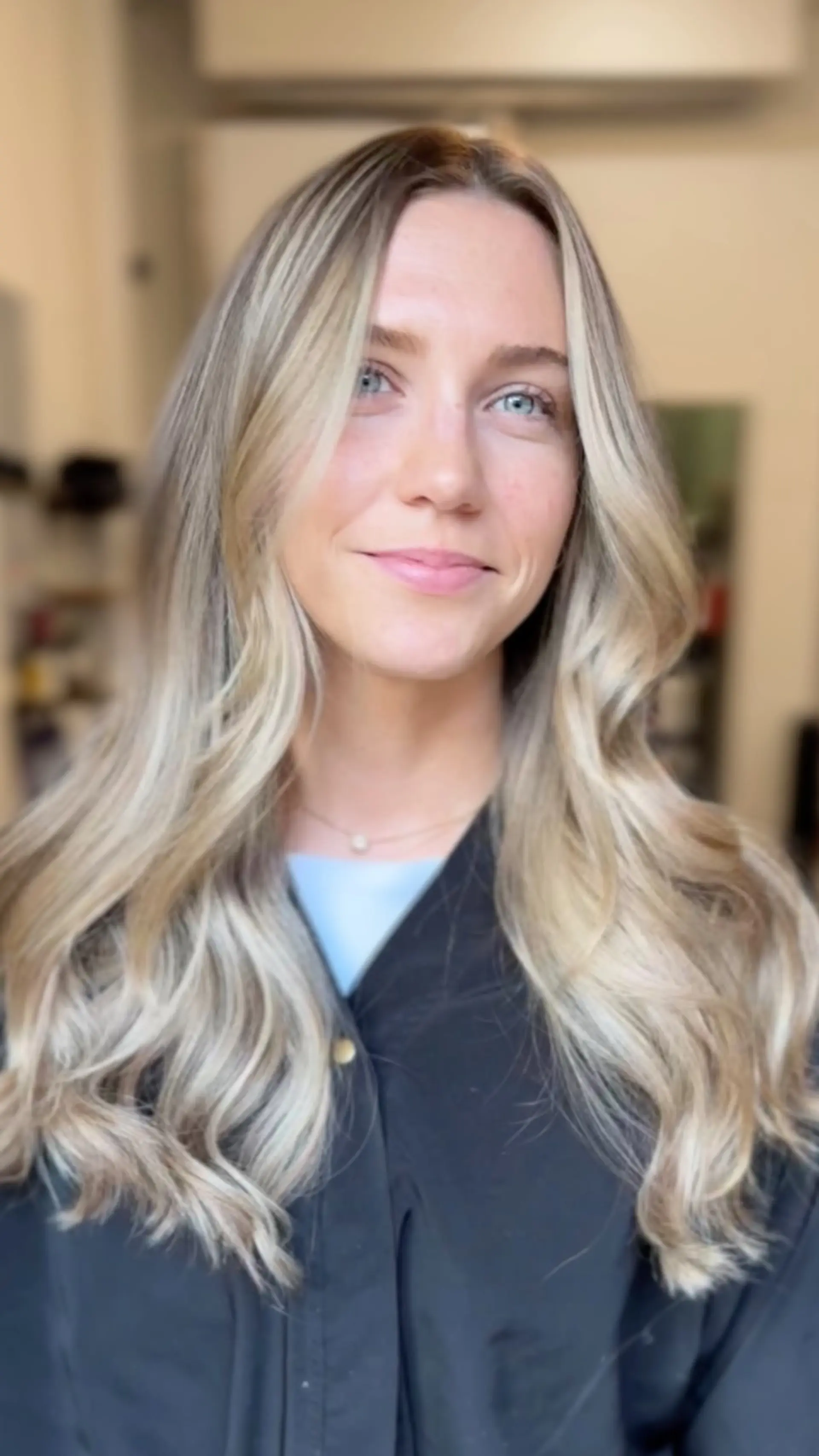 Long dimensional blonde hair styled in soft, voluminous waves with face-framing bright pieces. 1