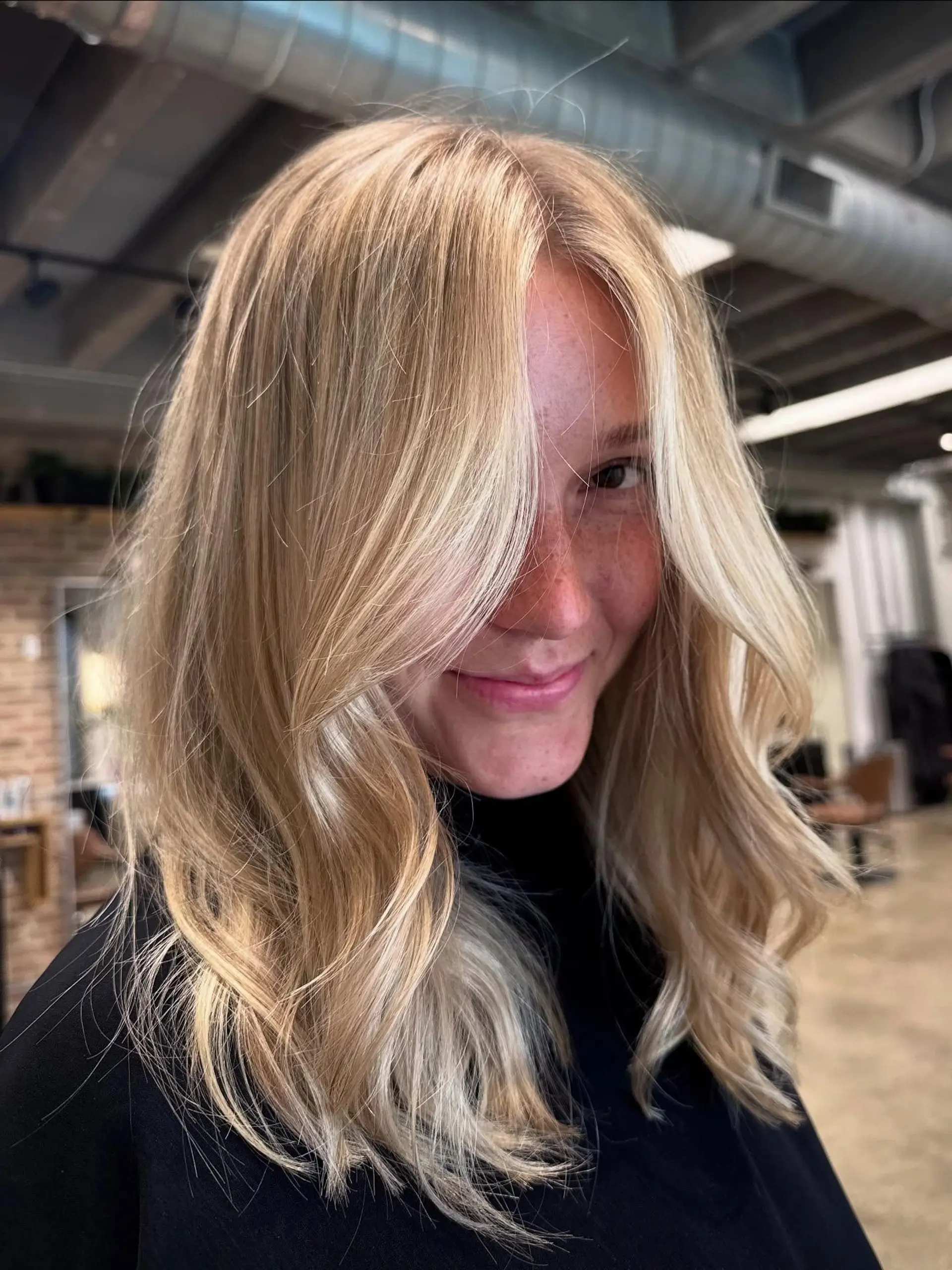 Medium-length, layered butterfly cut with face-framing curtain bangs and a natural wavy texture, creating volume and movement. 2