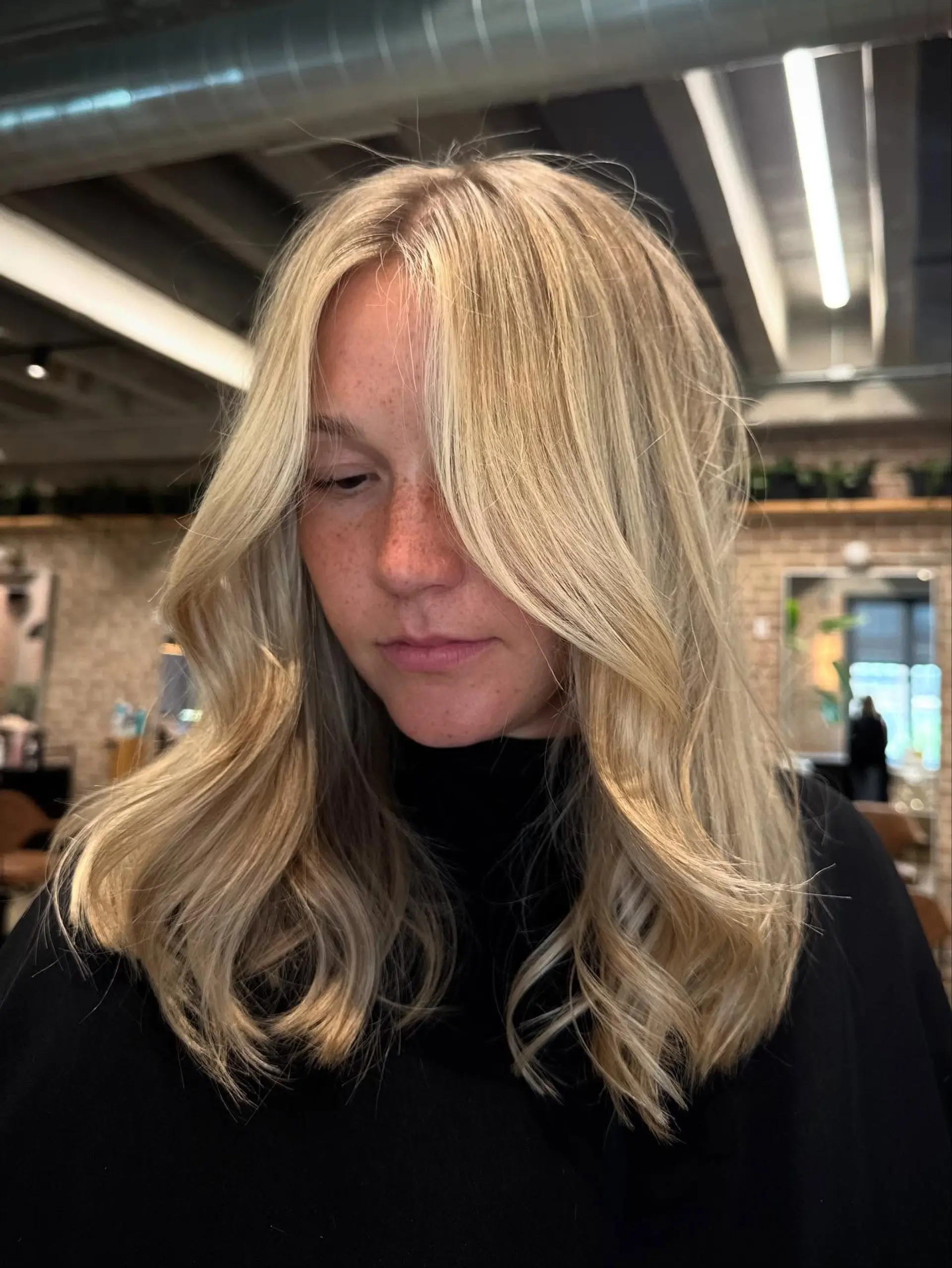 Medium-length, layered butterfly cut with face-framing curtain bangs and a natural wavy texture, creating volume and movement. 4