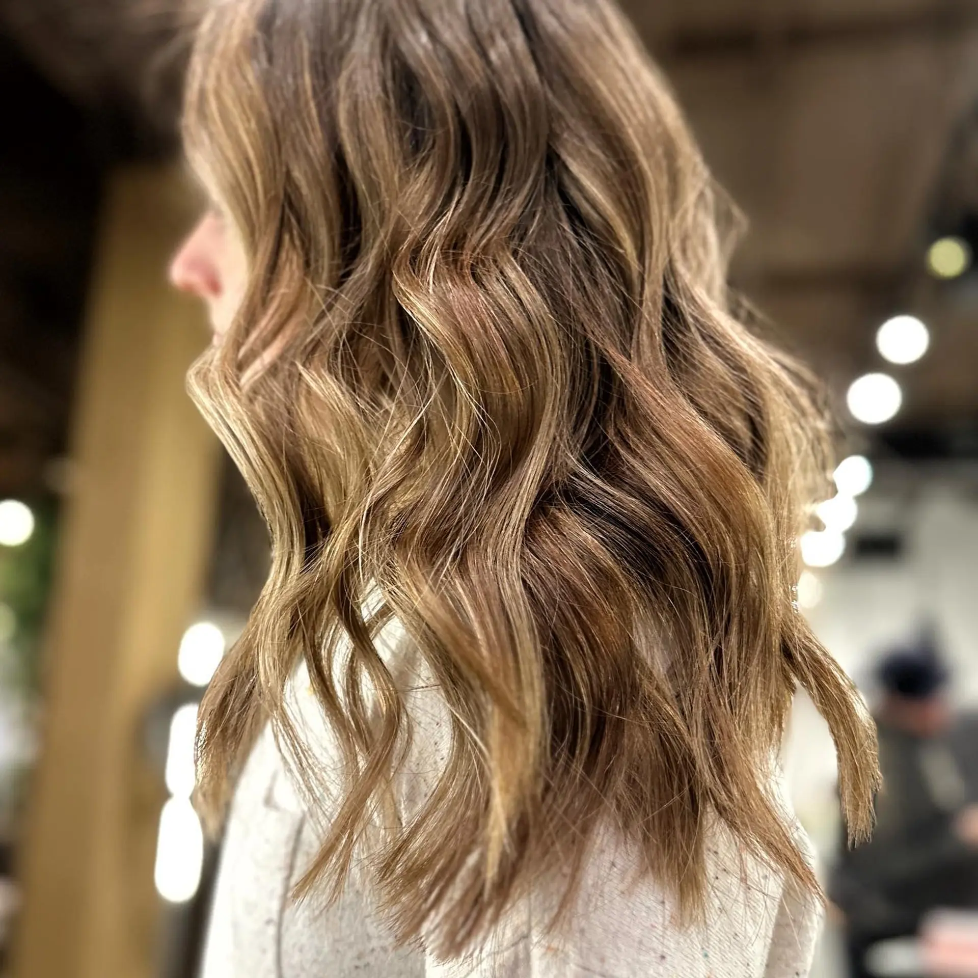 Medium-length wavy hair with a caramel balayage and root melt. 1