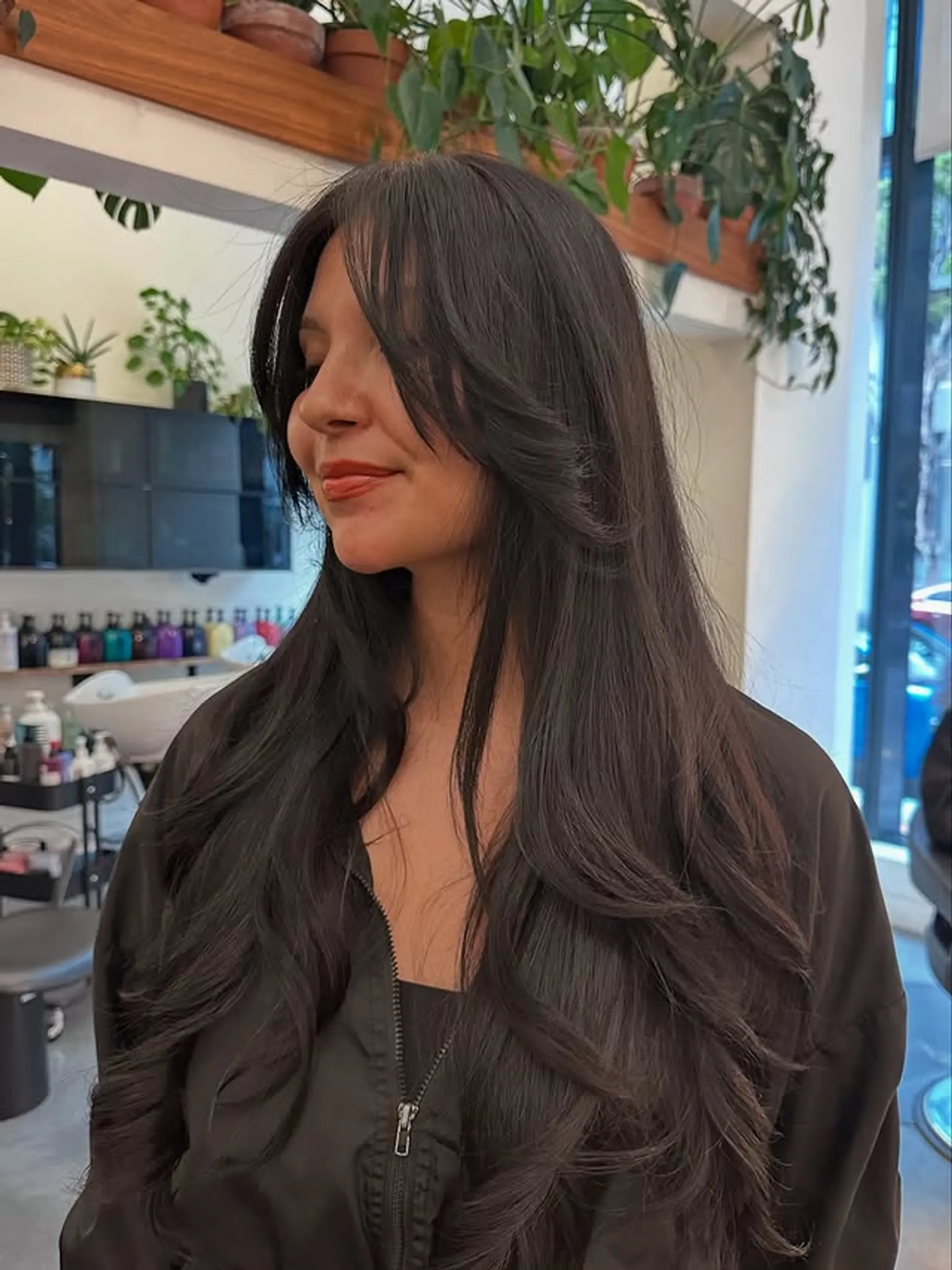 A long, layered cut with face-framing layers and curtain bangs. 1