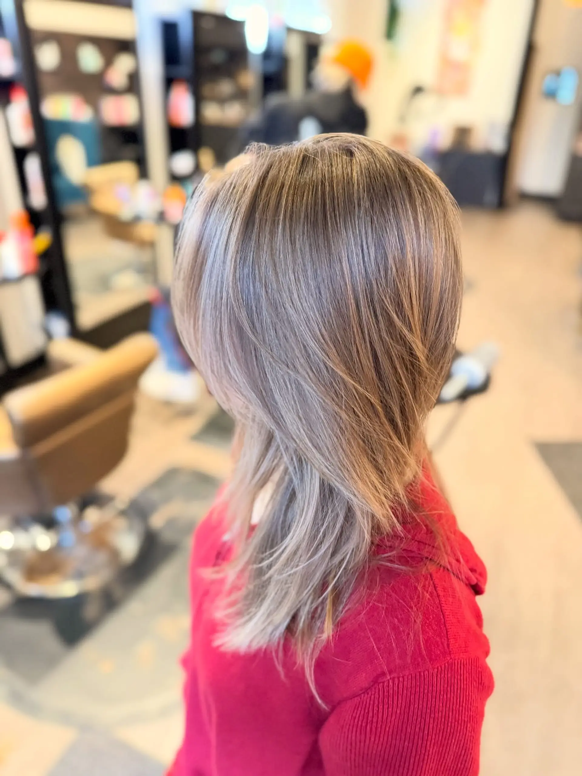 Medium-length haircut with face-framing layers and cool ash blonde foilayage highlights styled smooth. 1