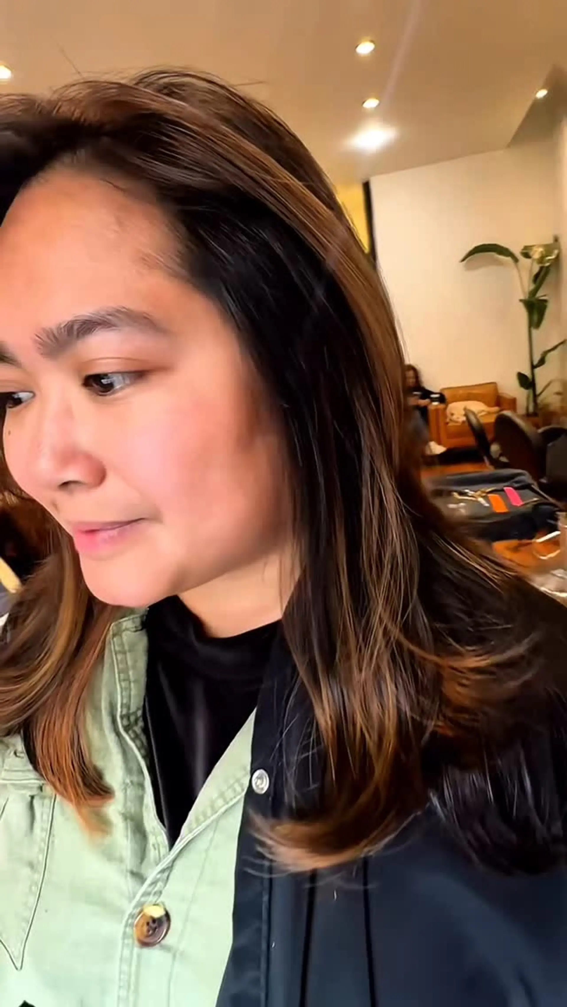 Medium-length dark brown hair featuring blended caramel highlights and softly layered ends curved under. 1