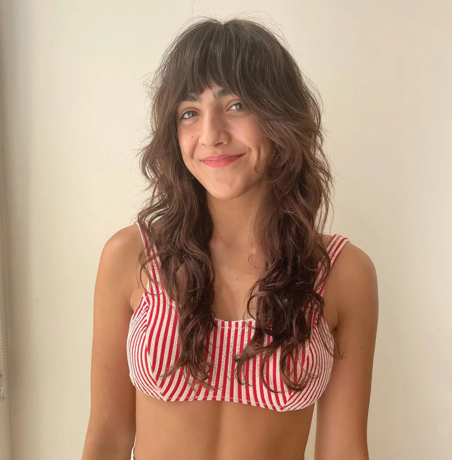 Long, wavy brown hair with textured layers and natural fringe. 1