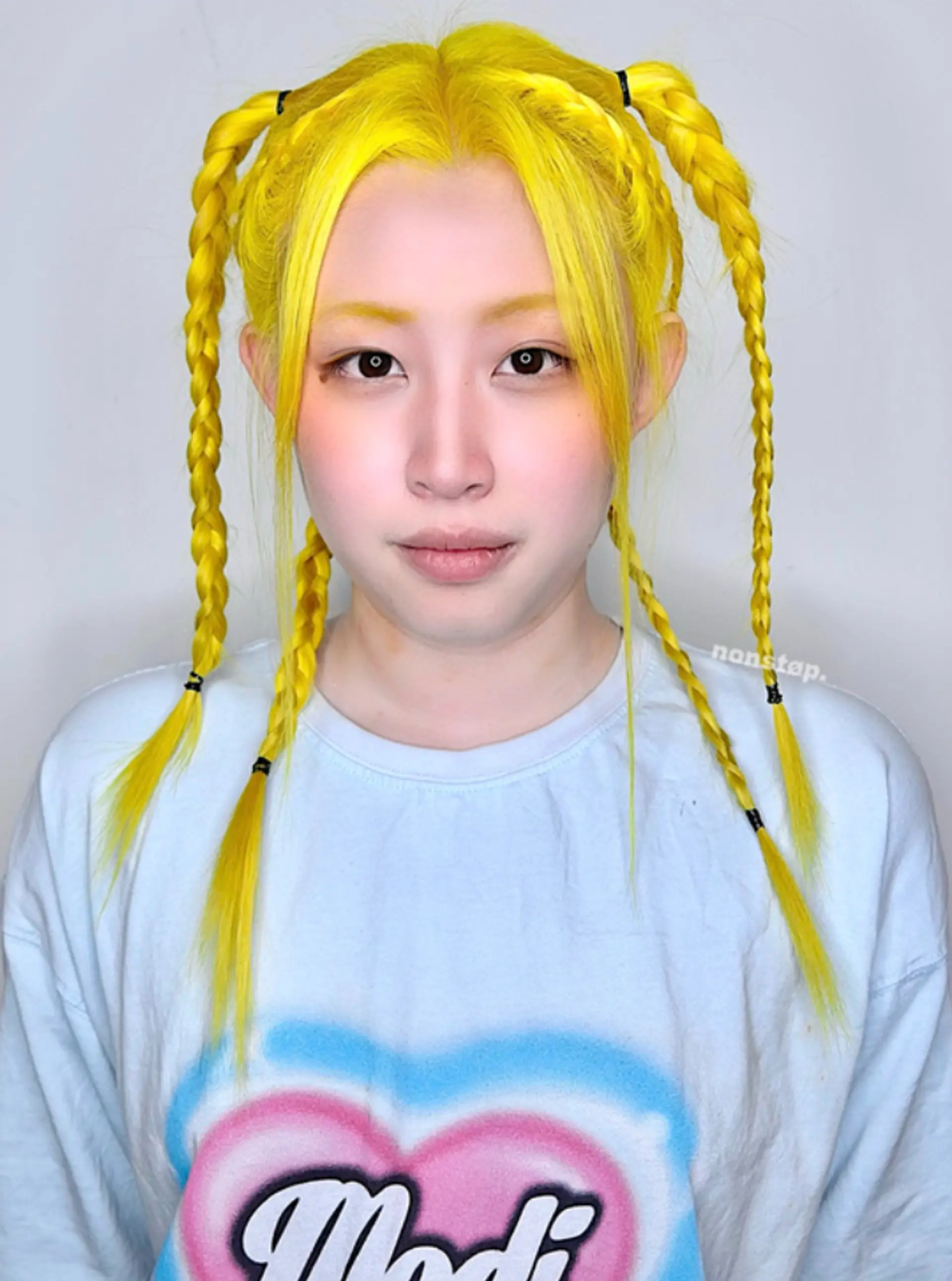 Bright yellow hair is parted in the middle and sectioned into four symmetrical braids, two on each side, creating sleek, straight pigtail braids that are secured with small bands.
(NonstopStyle: by Vincent) 1