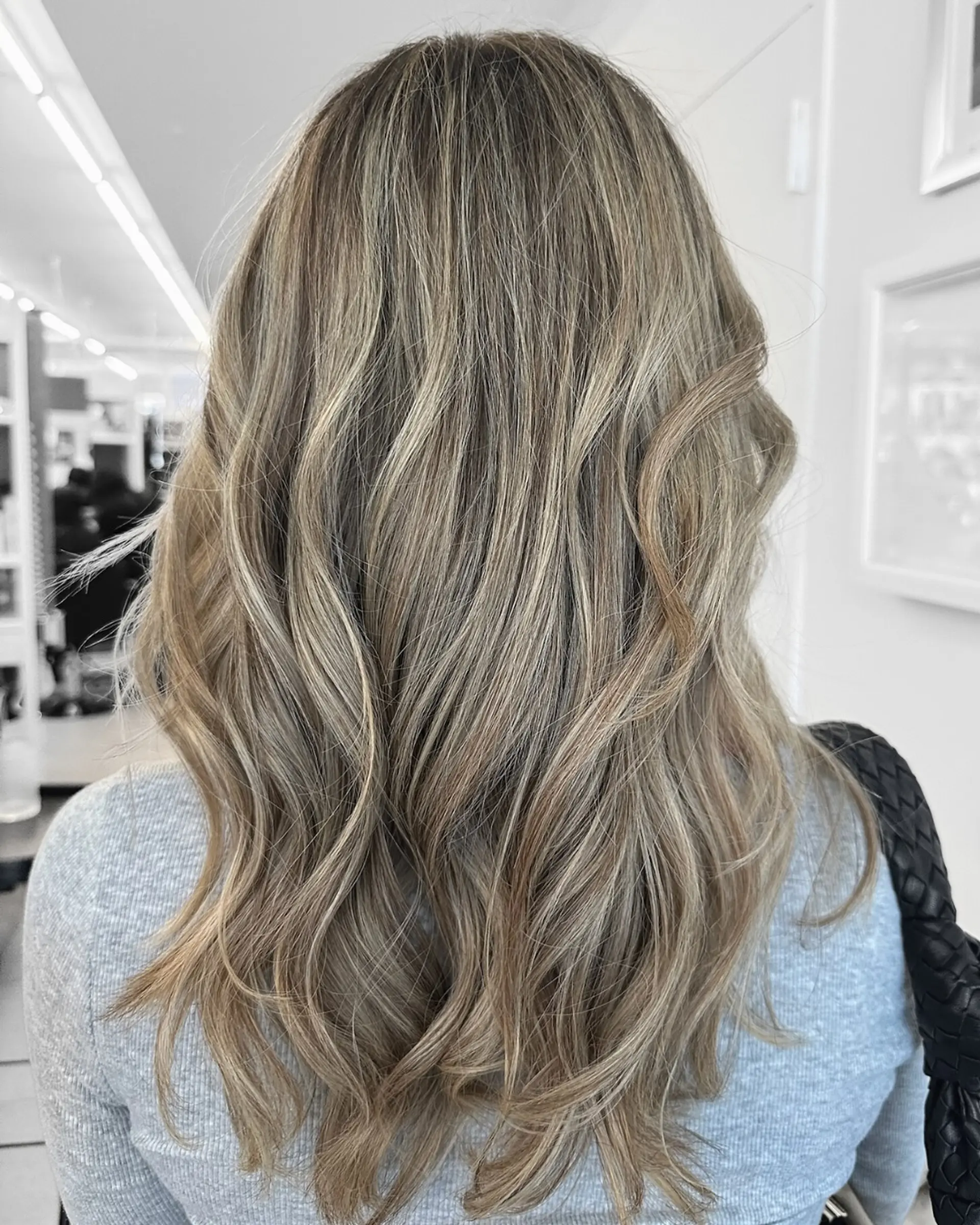 Long ash blonde hair with soft beach waves and dimensional highlights. 1