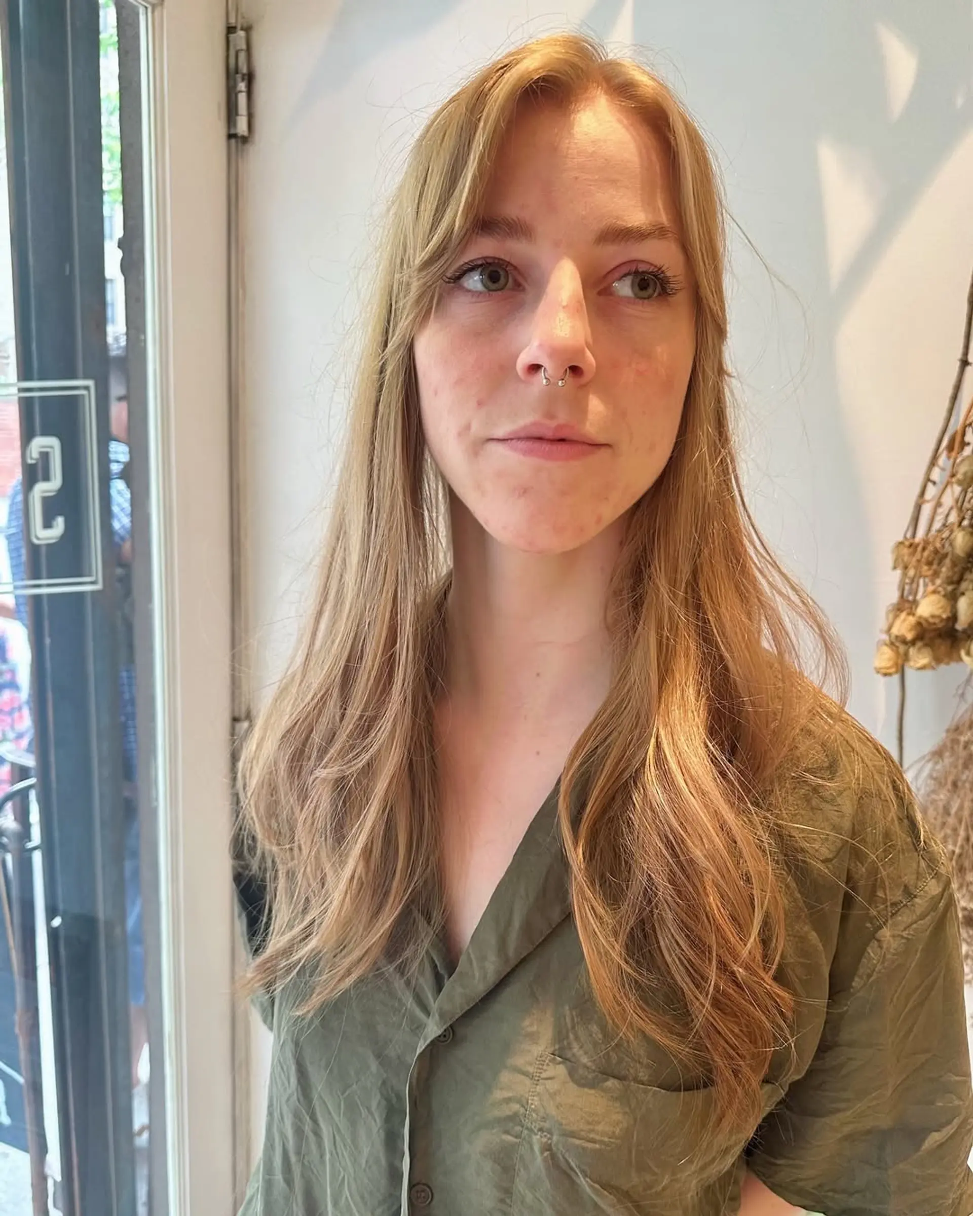 Long layered haircut with face-framing curtain bangs. 1