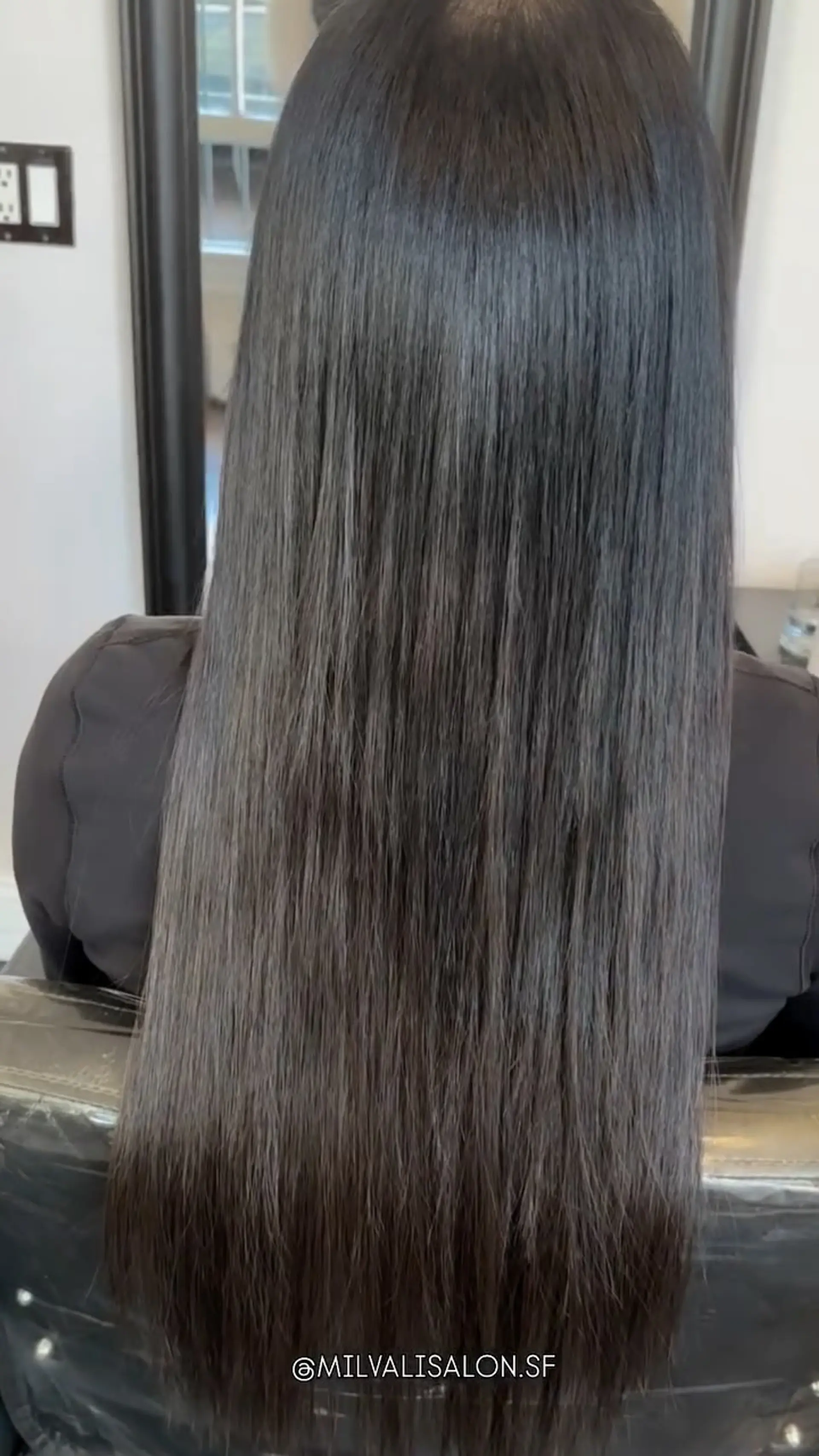 Long, sleek straight dark hair seamlessly blended with weft extensions for added length and fullness. 1