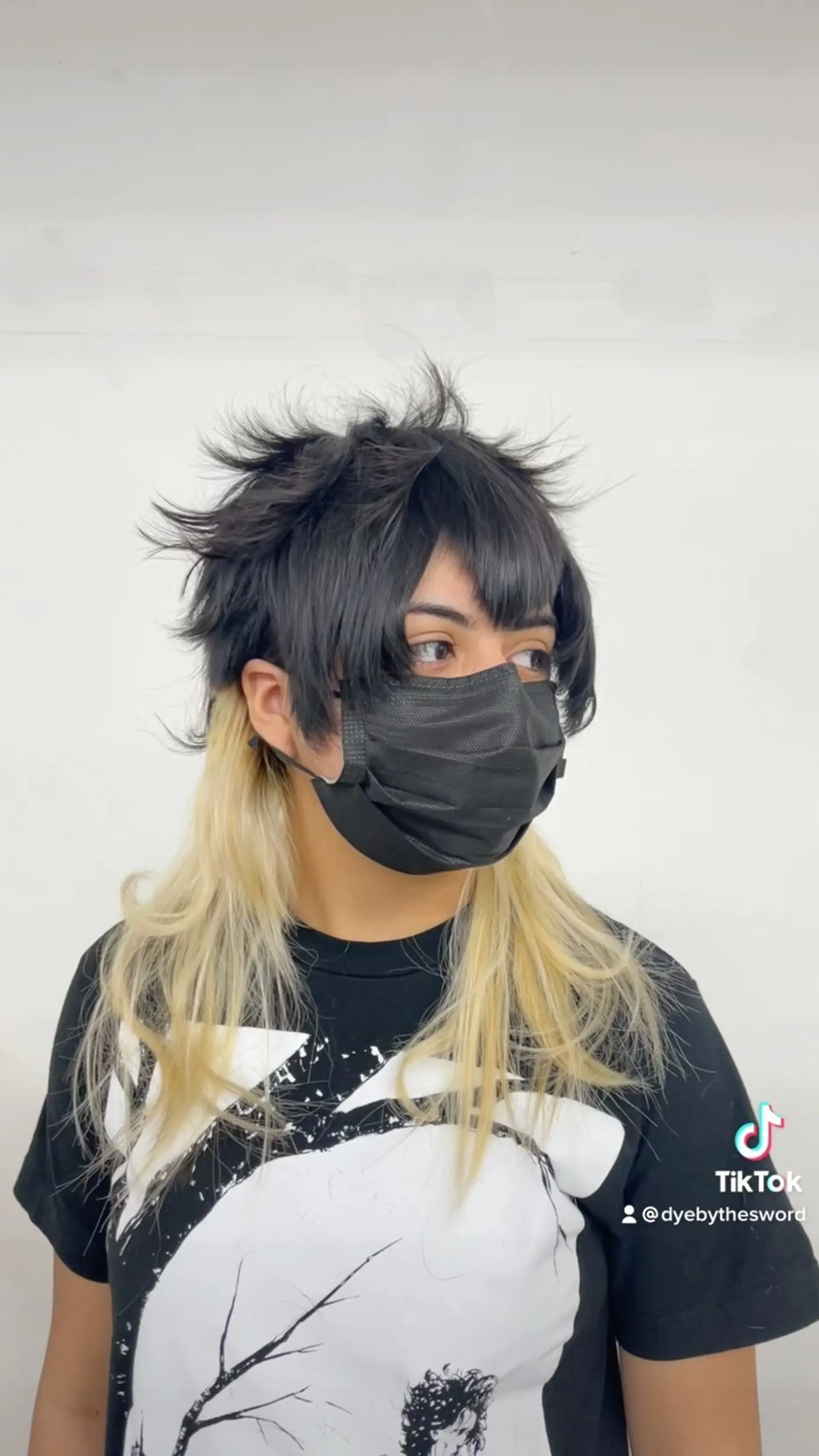 A visual kei and anime-inspired textured wolf cut mullet featuring choppy, spiky black layers on top with fringe and long, straight bleached-blonde hair at the base. 1