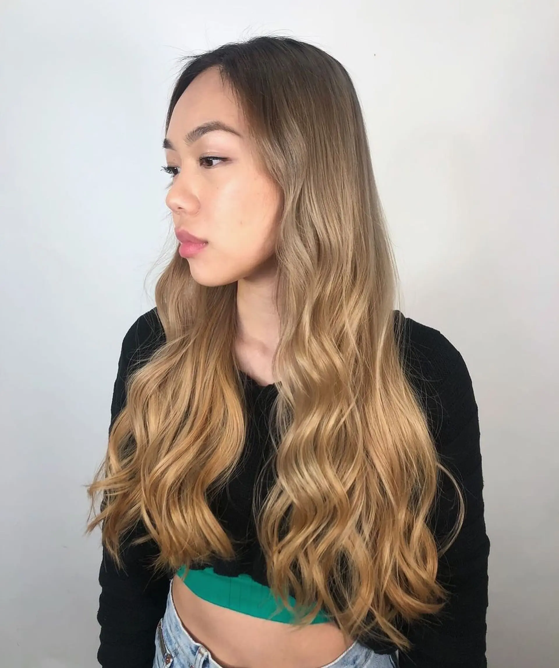 A very long, wavy hairstyle with a gradient from dark blonde roots to golden blonde tips, styled with a middle part and loose, flowing waves.
Stylist - @xcellent_jason 1