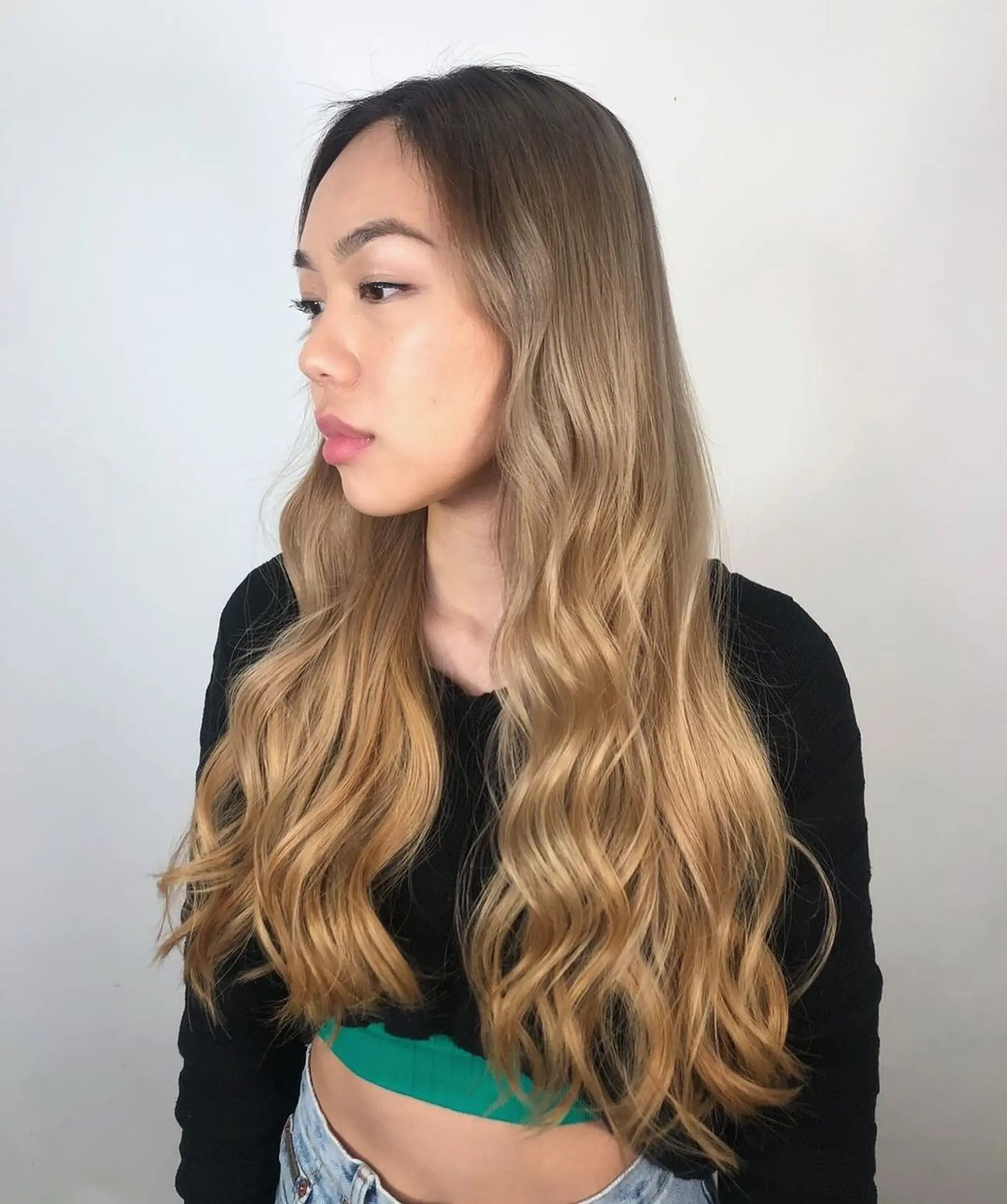 A very long, wavy hairstyle with a gradient from dark blonde roots to golden blonde tips, styled with a middle part and loose, flowing waves.
Stylist - @xcellent_jason