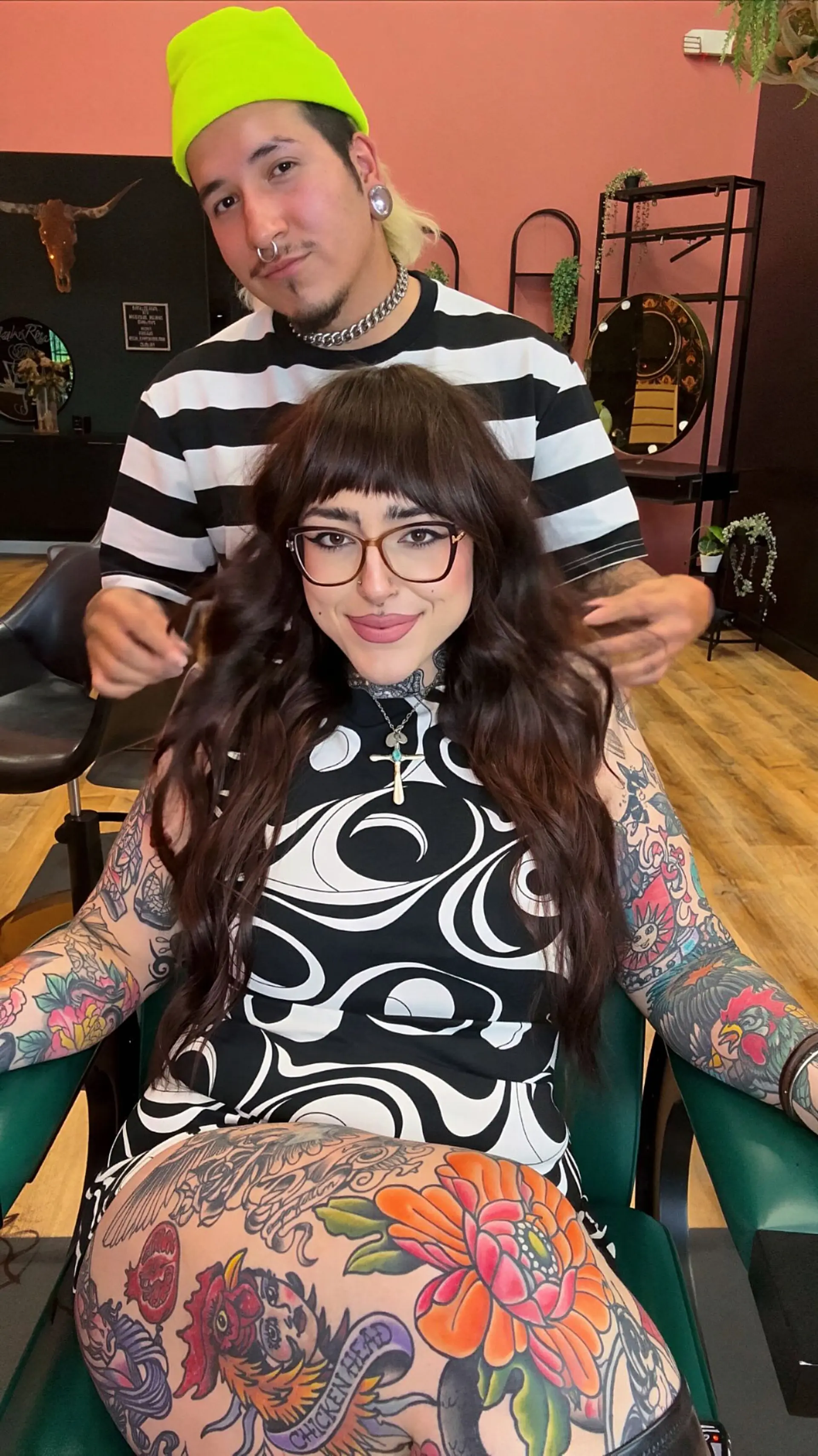 Long dark brown hair styled with voluminous textured waves and full blunt bangs. 1