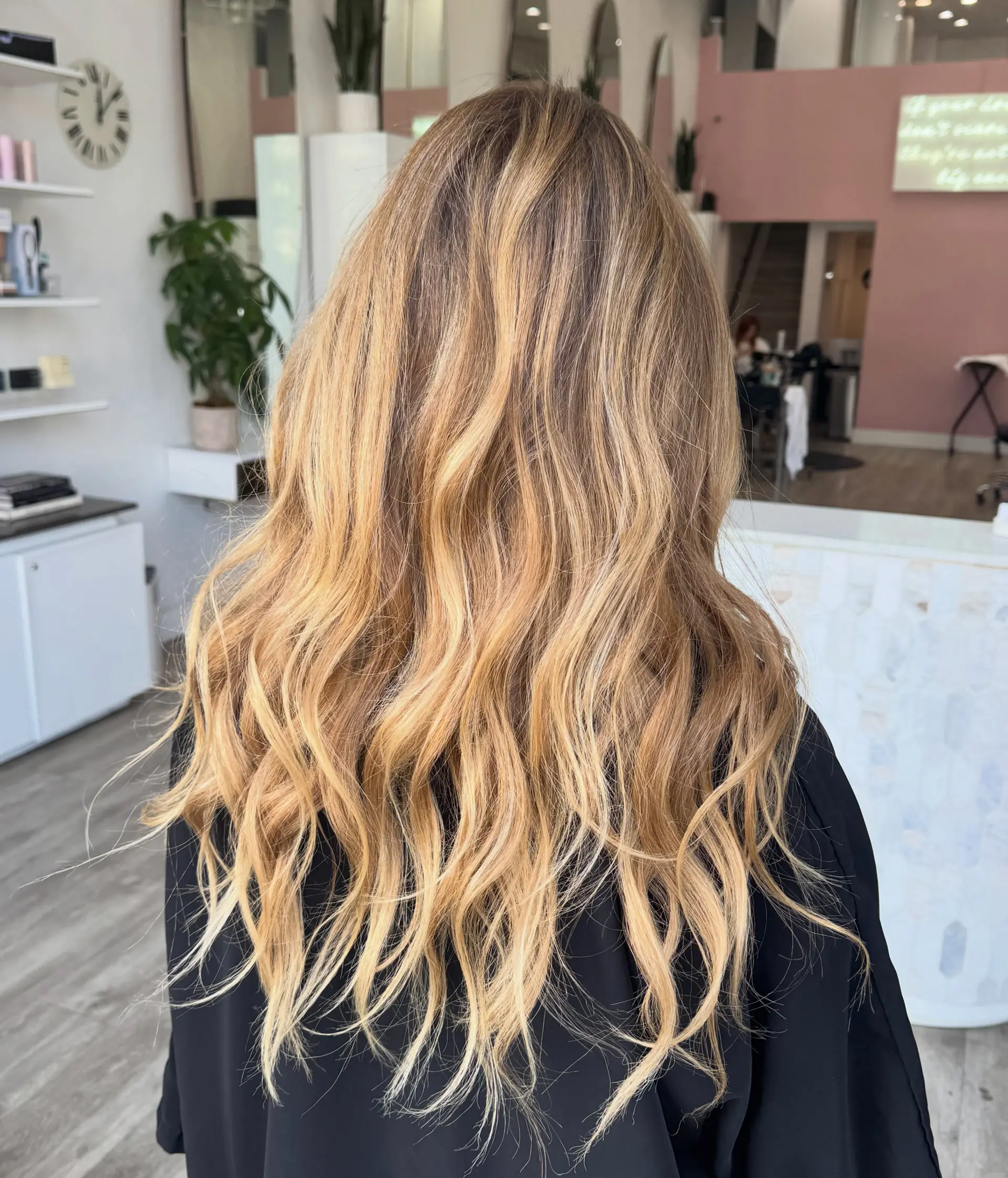 Long sun-kissed bronde hair styled with textured, effortless beach waves. 1