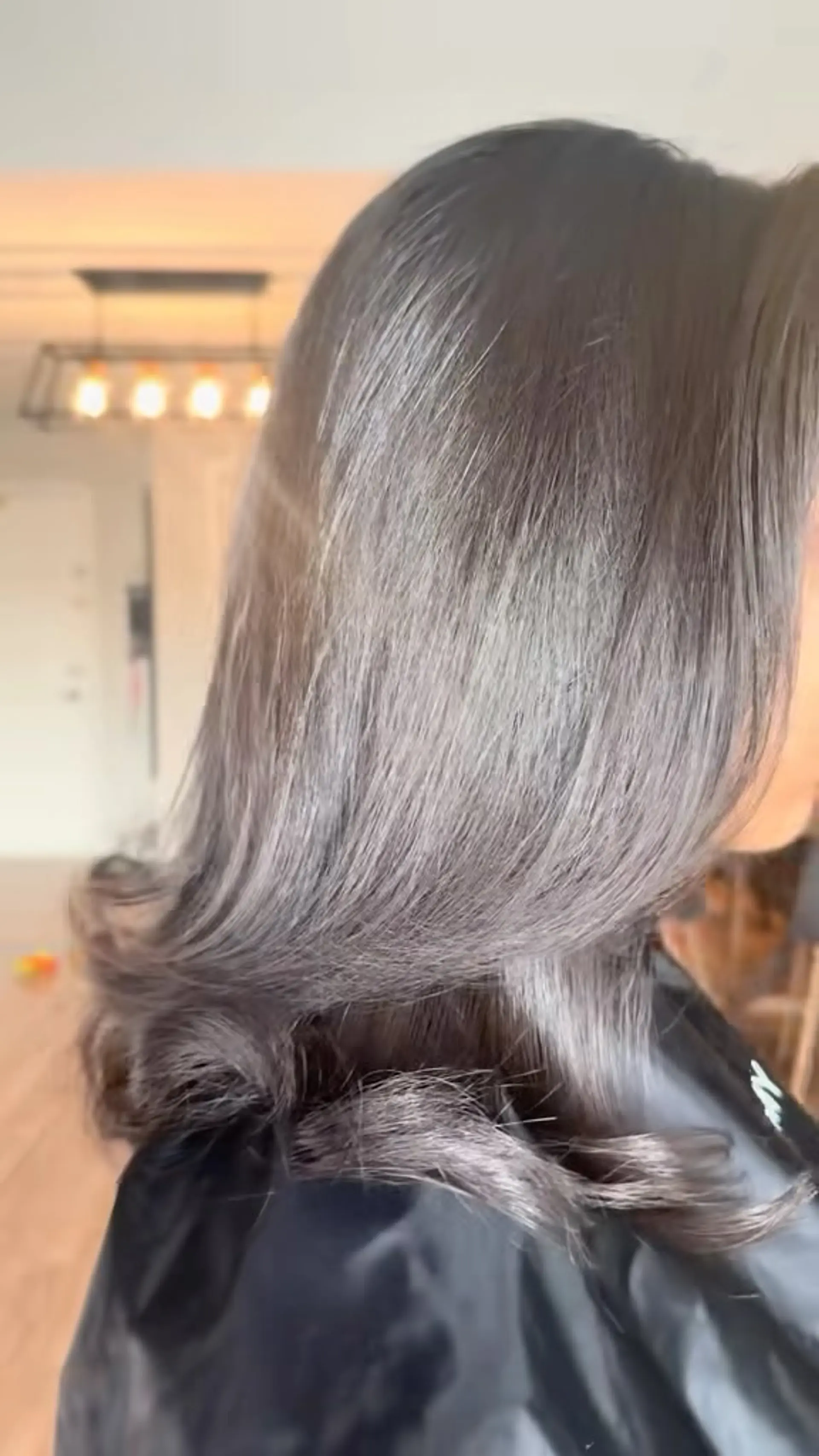 A sleek, high-shine brunette blowout featuring smooth lengths and defined outward-flipped ends. 1