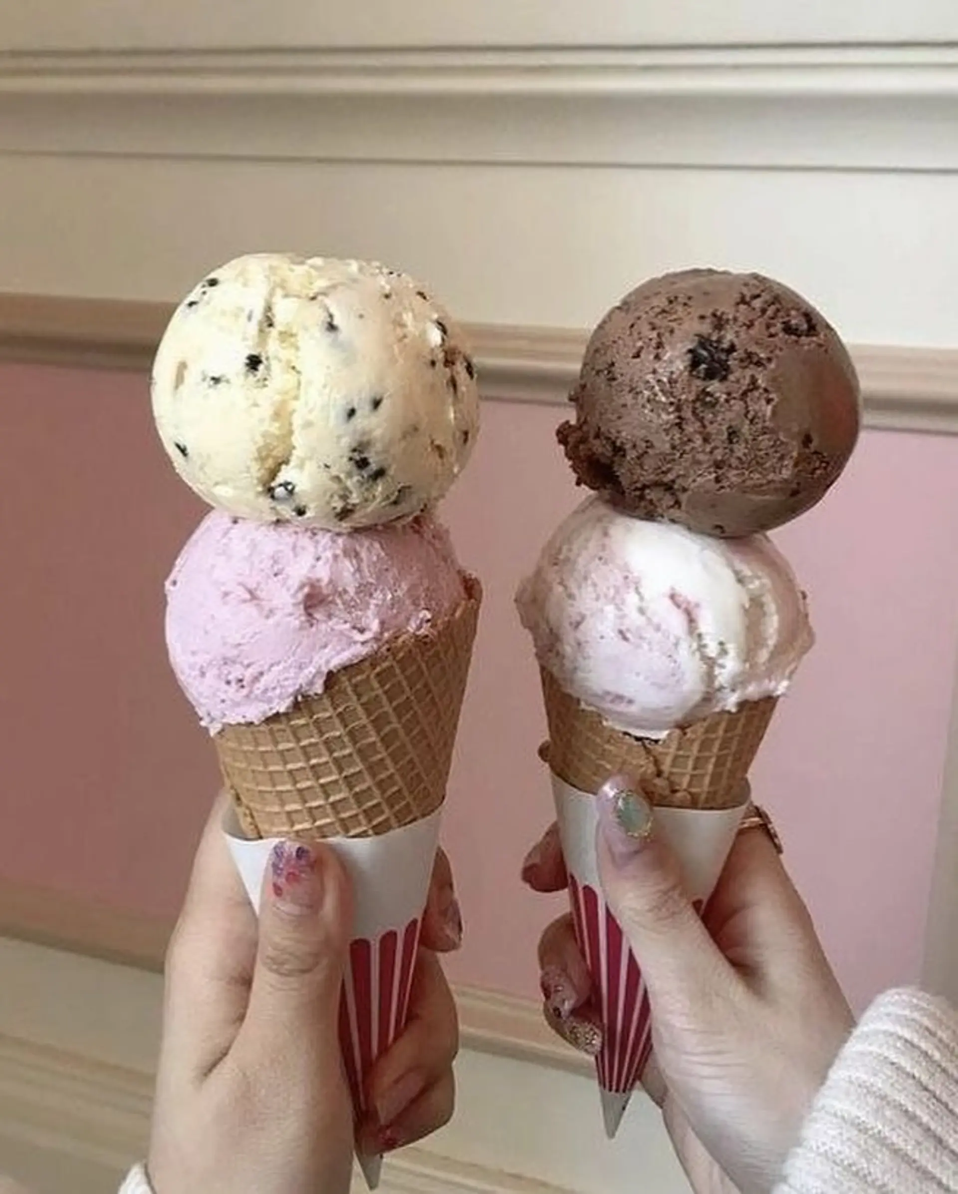 This bold pixie bob features a multi-tonal color block design, incorporating vivid and pastel pinks, light blonde, and a dark brown section for a striking contrast. The cut is layered, ending above the nape, and styled with a blunt fringe. 2