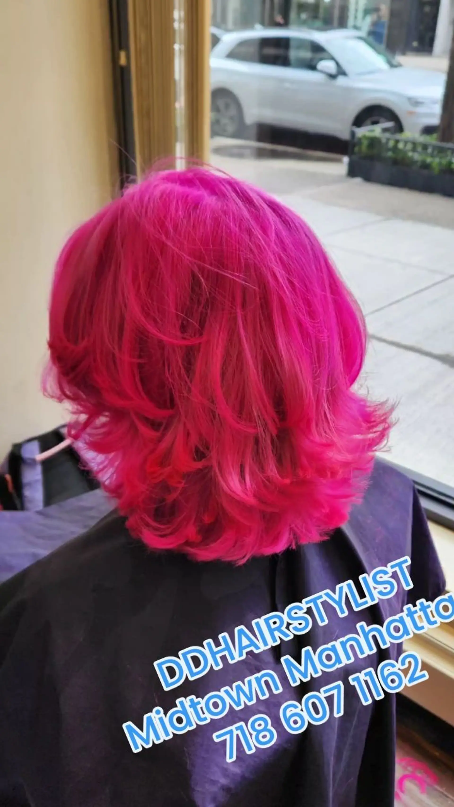 A vibrant hot pink medium-length layered haircut styled with voluminous, outward-flipped ends. 1