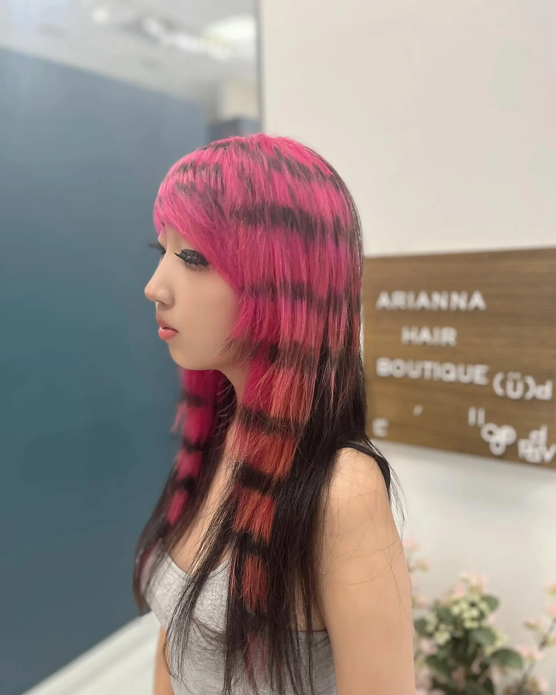 Long straight layered scene haircut featuring bold pink sections with horizontal black raccoon tail stripes. 1