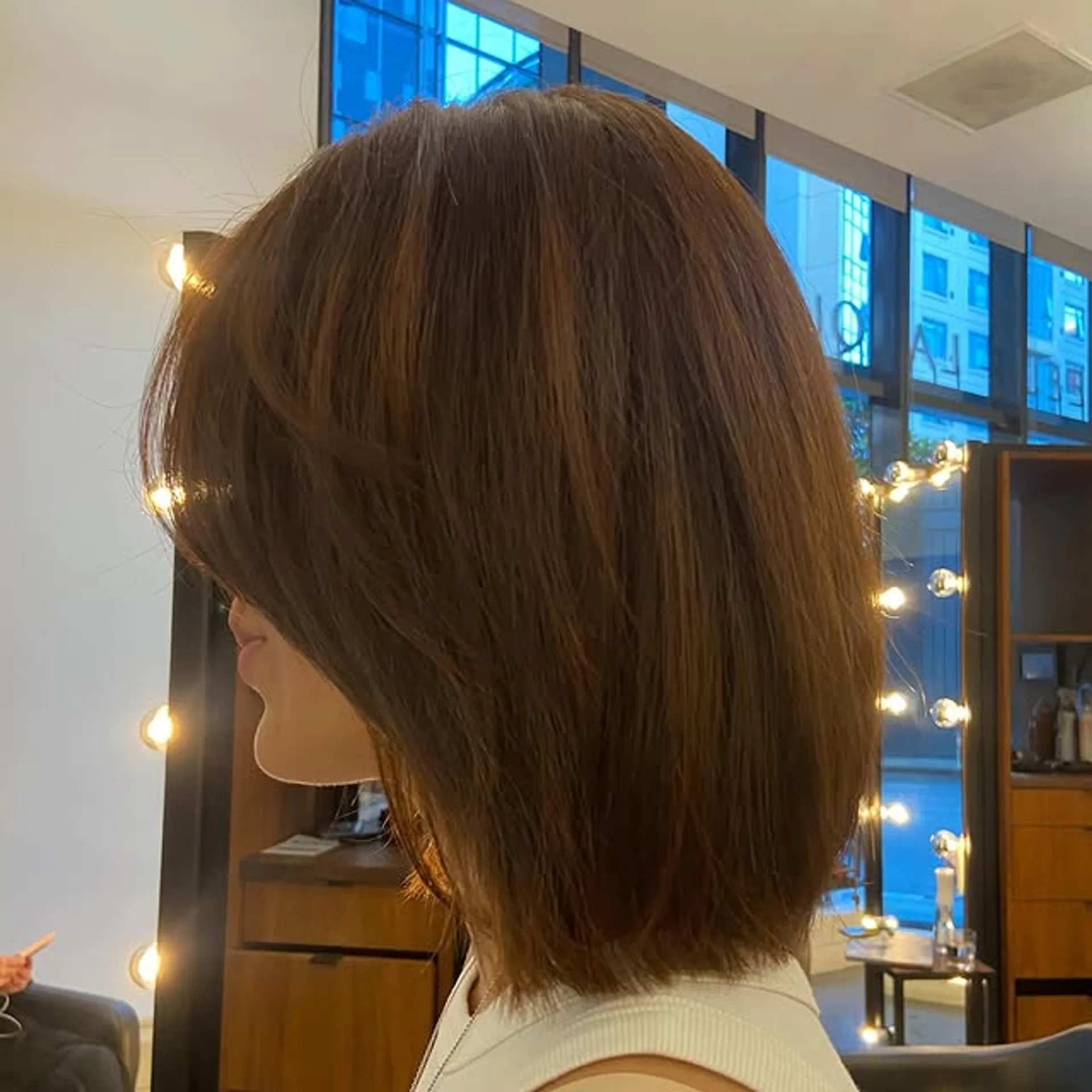 A woman with a chic square bob and elegant curtain bangs, showcasing a modern and sophisticated hairstyle. - Preview 3