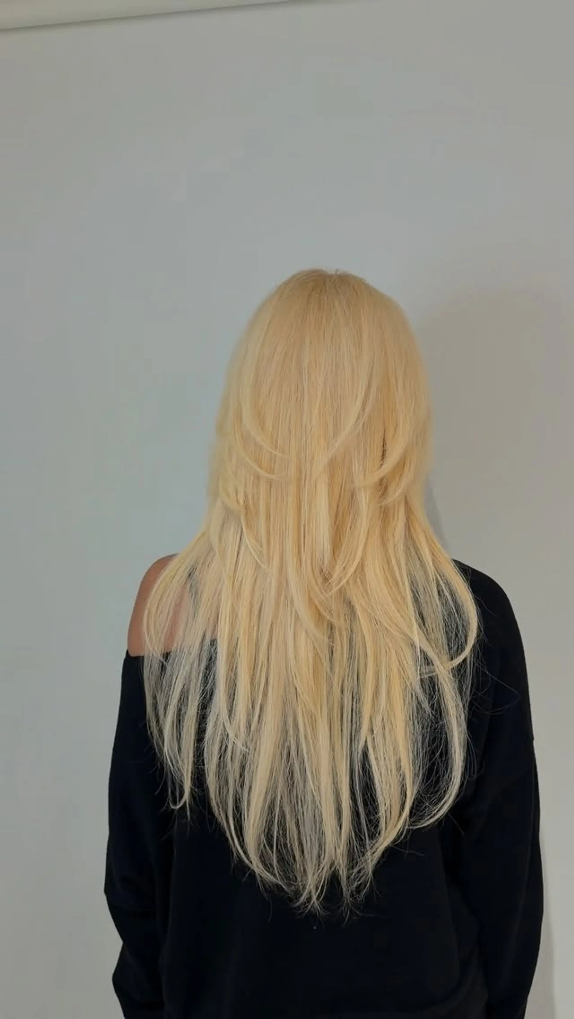 Long, flowing platinum blonde hair with cascading feathered layers and soft, rounded ends. 1