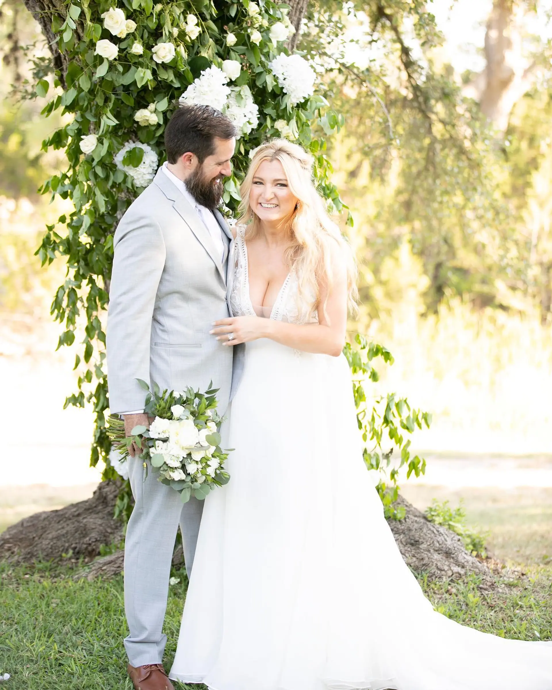 Romantic half-up bridal hairstyle featuring soft, flowing blonde waves. 1