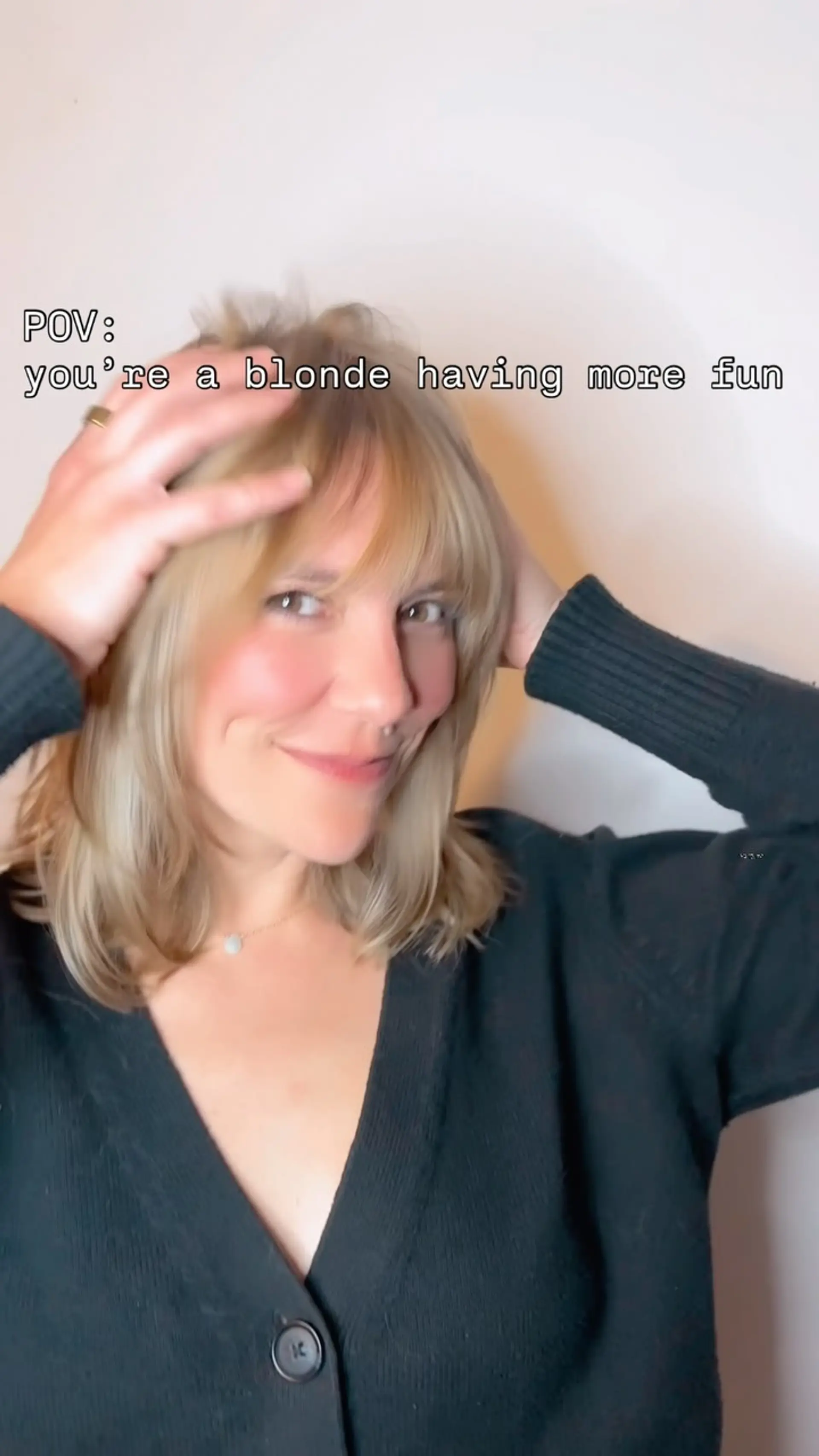 A warm blonde shoulder-length lob featuring soft layers and wispy, brow-grazing bangs. 1
