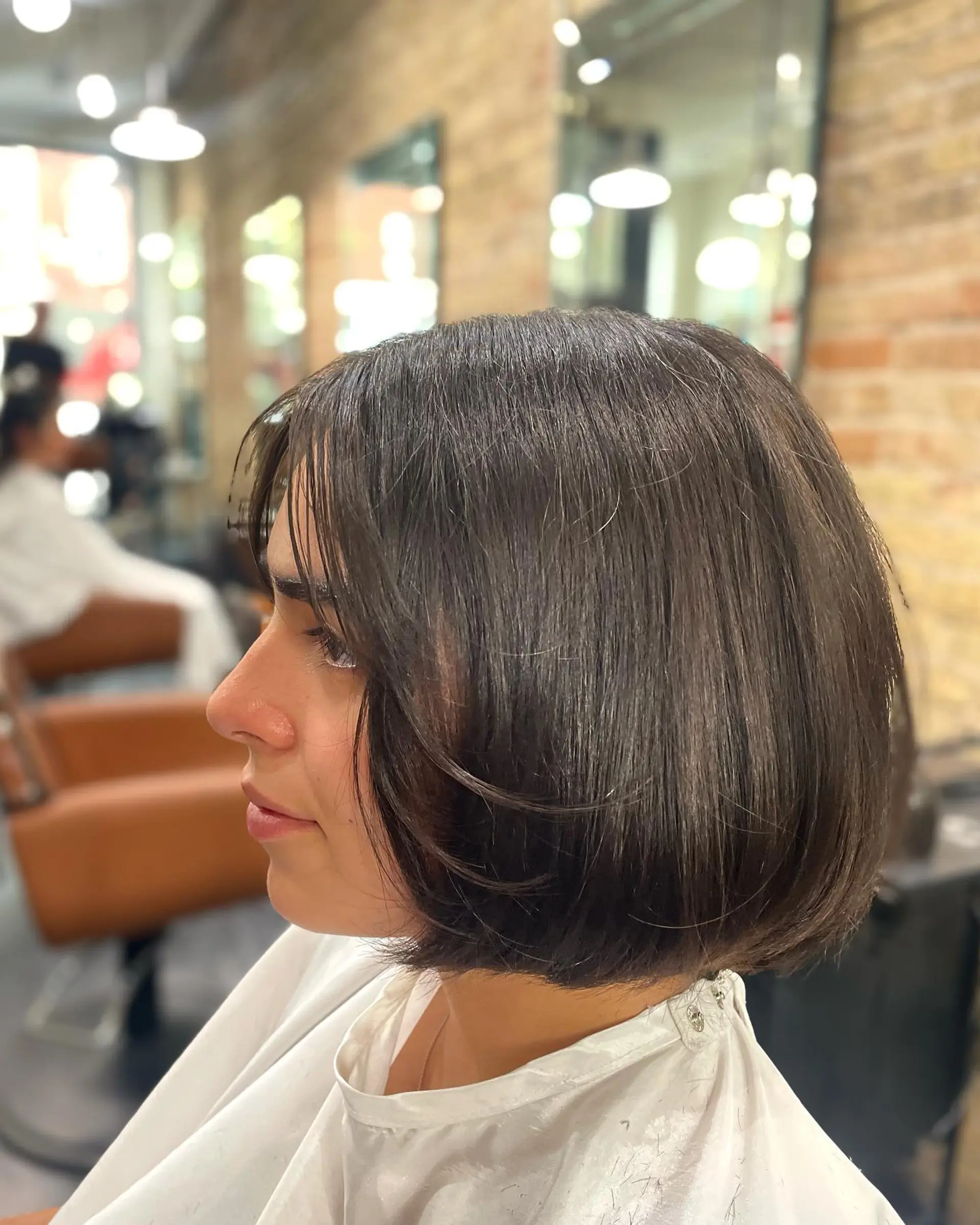 A sleek chin-length French bob cut with rounded ends and light, face-framing bangs. 1