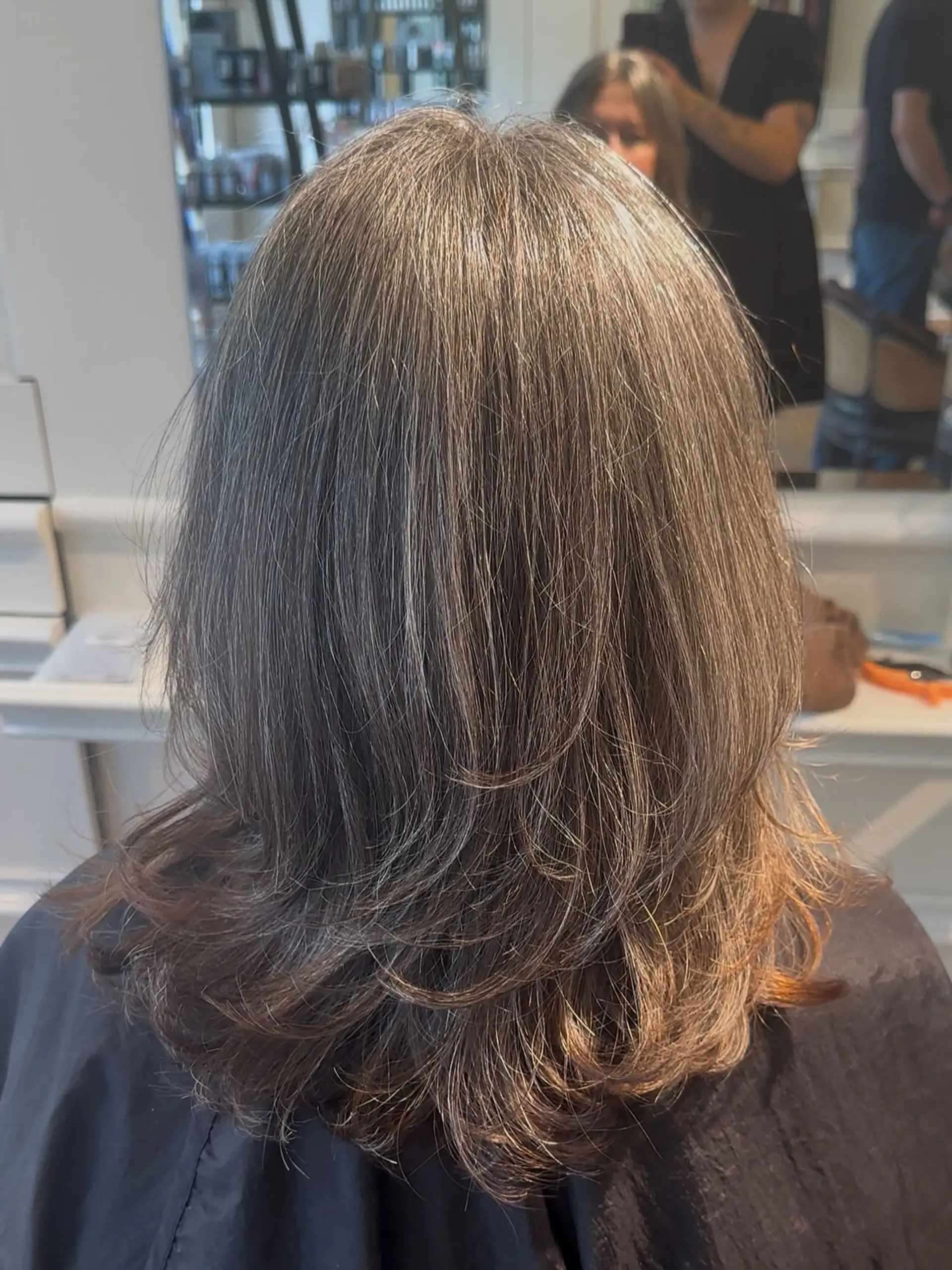 Medium-length haircut with textured layers and softly flipped ends. 1