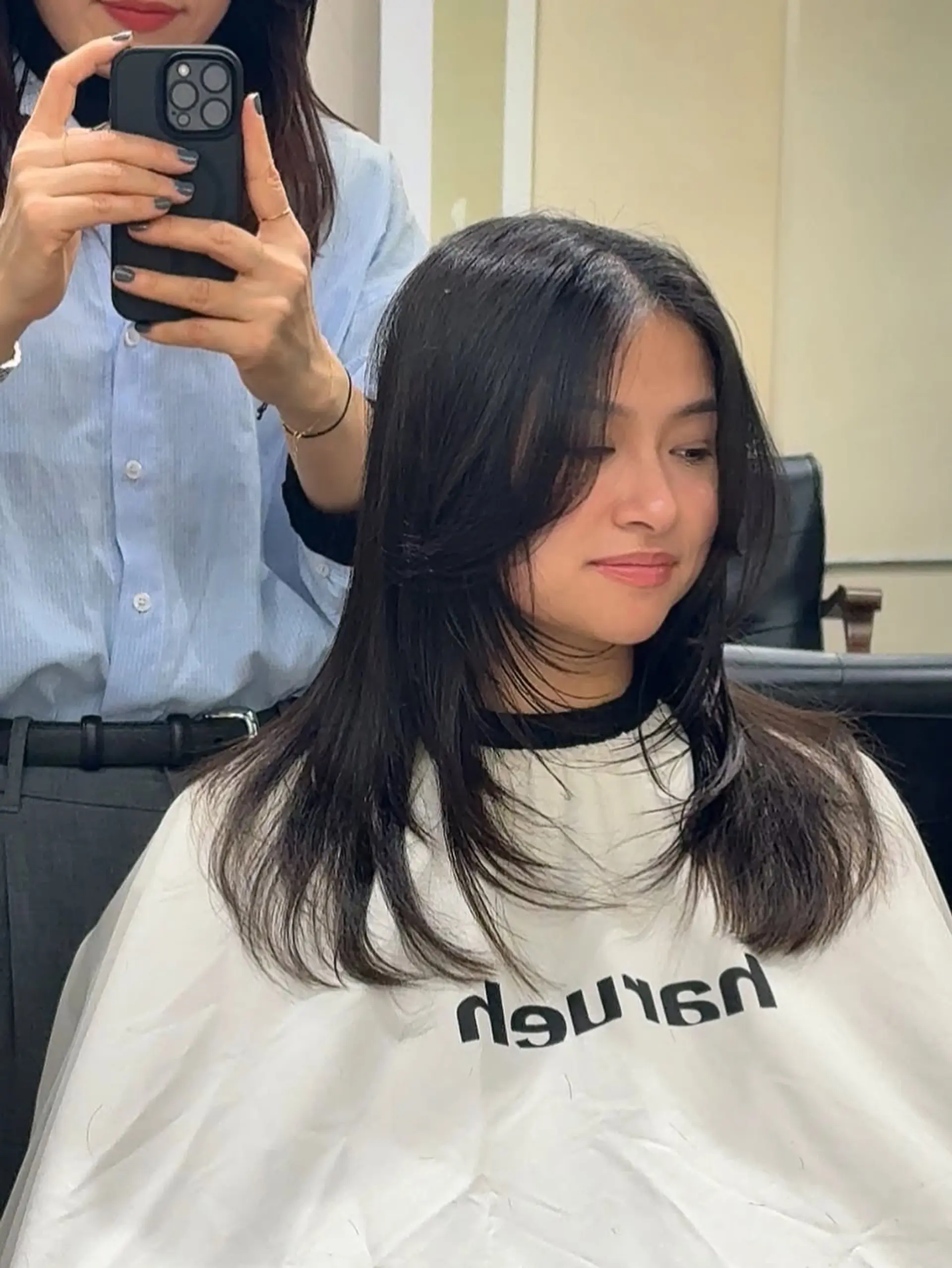 A layered cut featuring face-framing curtain bangs that blend seamlessly into the length, providing a soft, flattering aesthetic around the face. 1