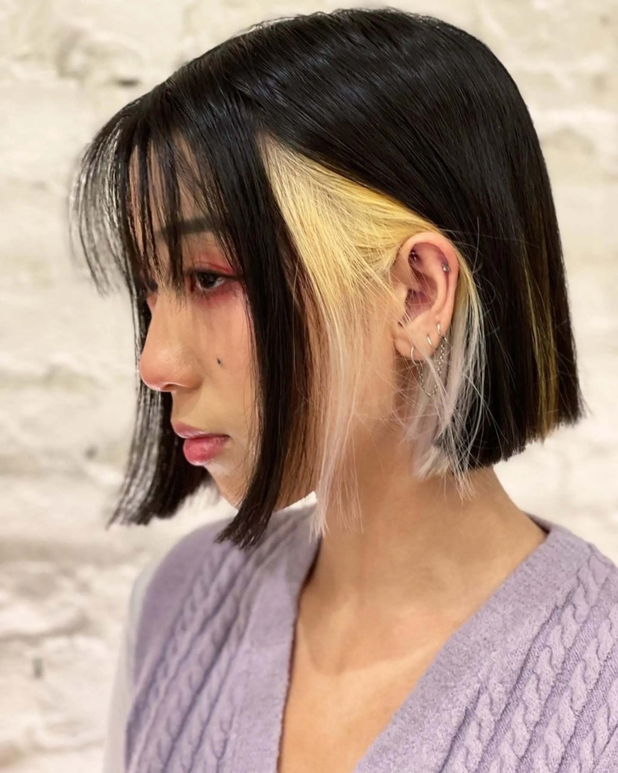 A chic blunt bob with bold face-framing highlights.
