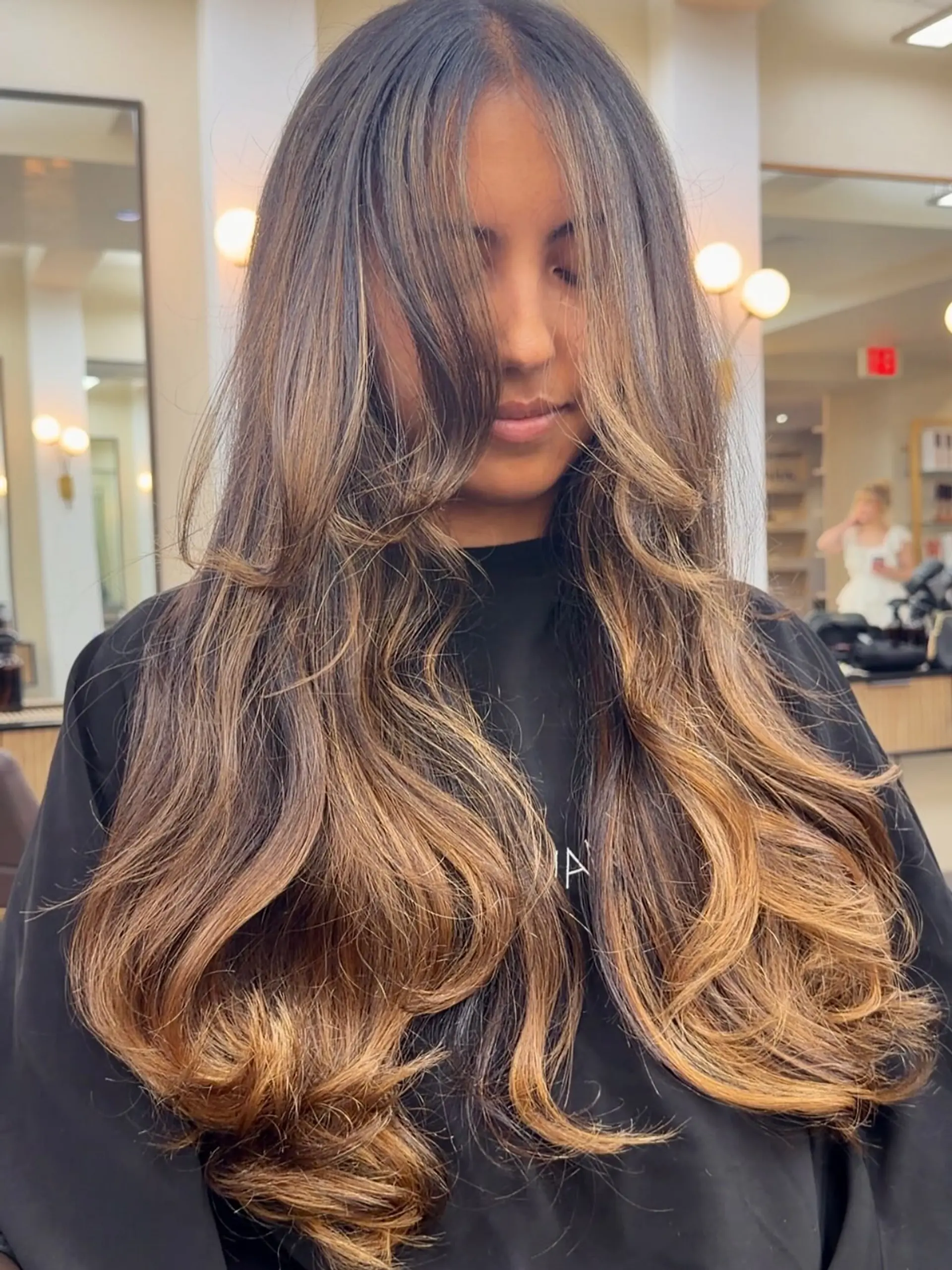 Extra-long layered hair featuring a warm caramel balayage and voluminous curtain-style face-framing layers. 1