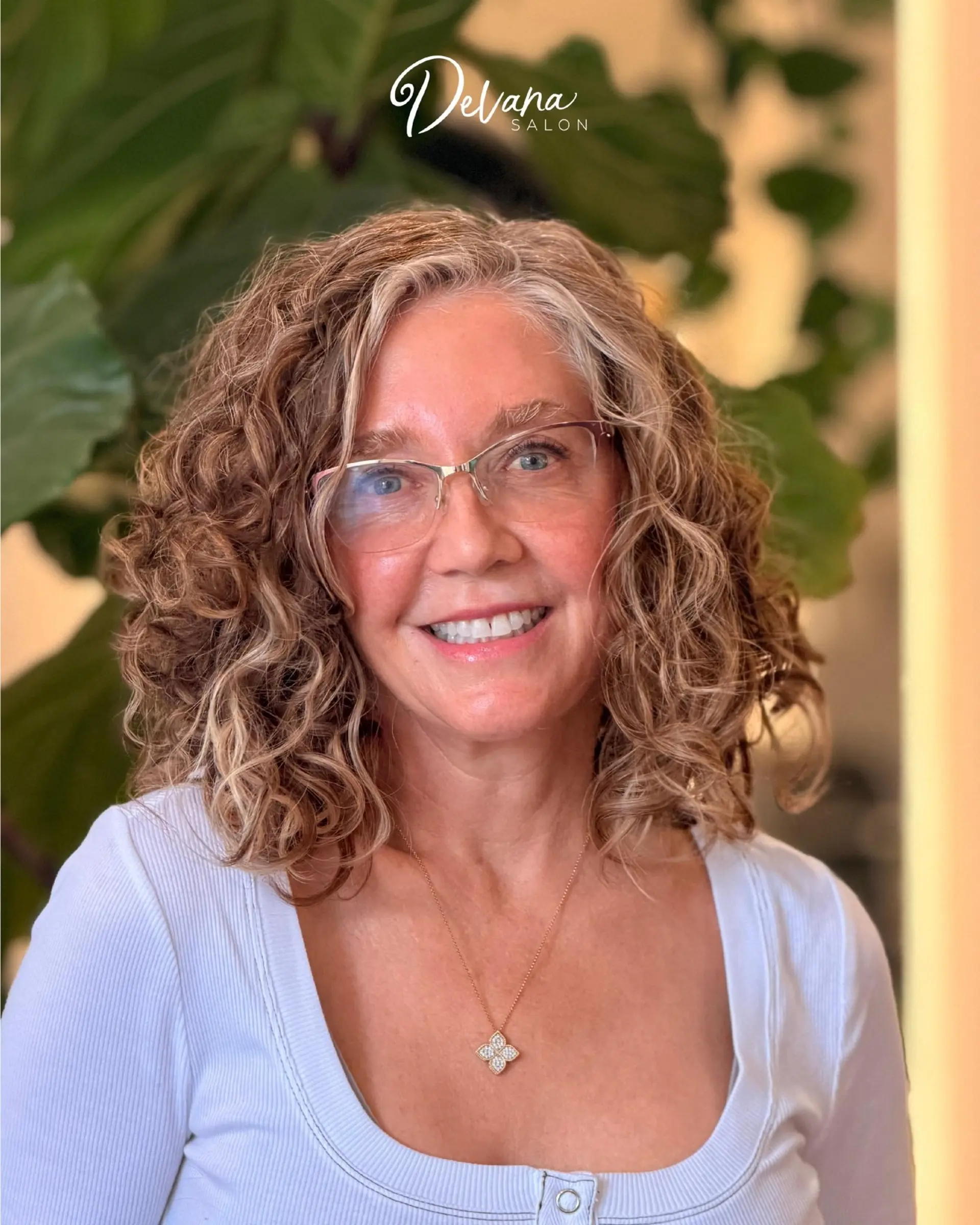 Medium-length curly cut with warm dimensional highlights blended into natural gray. 1