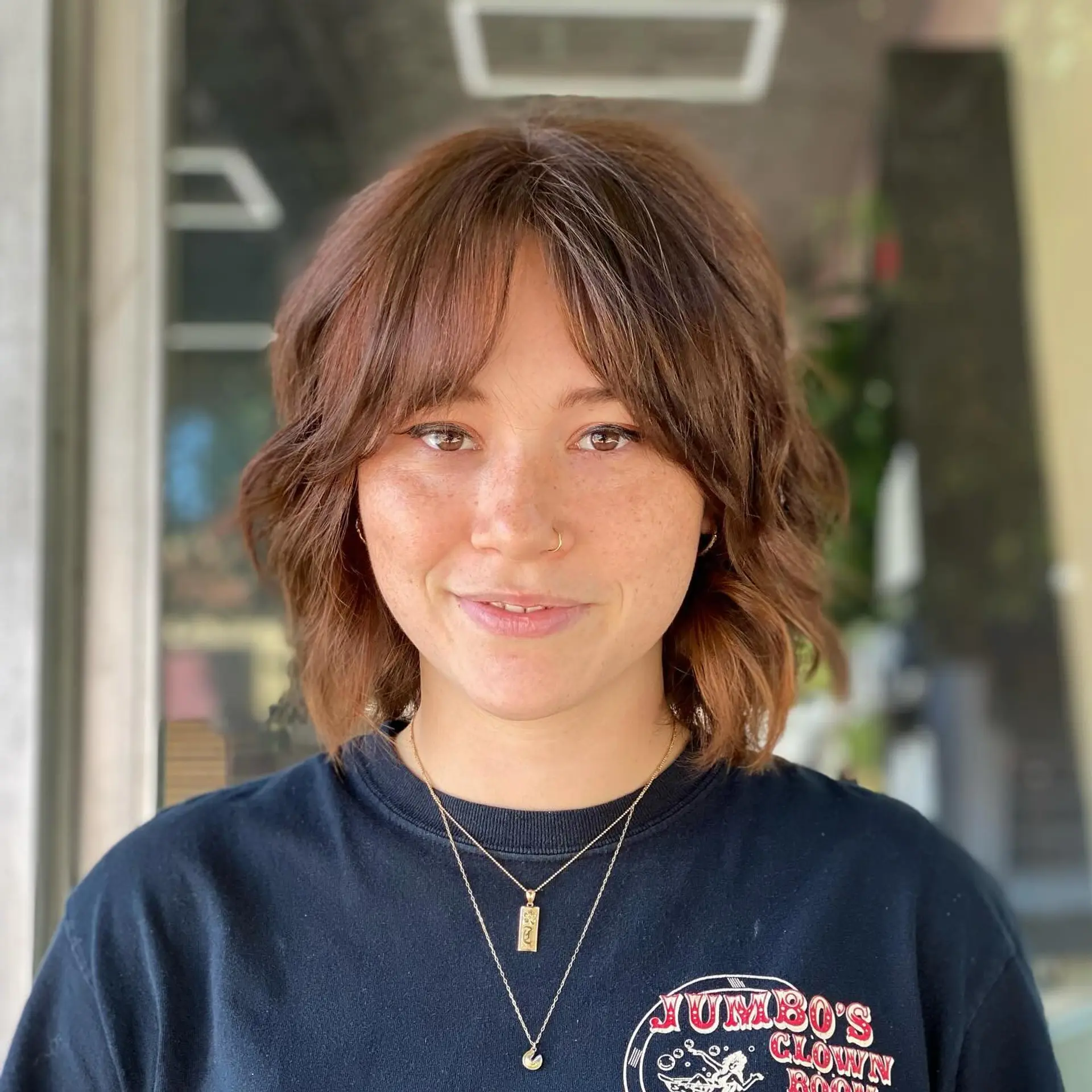 A warm brown shaggy bob featuring choppy layers, relaxed waves, and soft face-framing fringe. 1