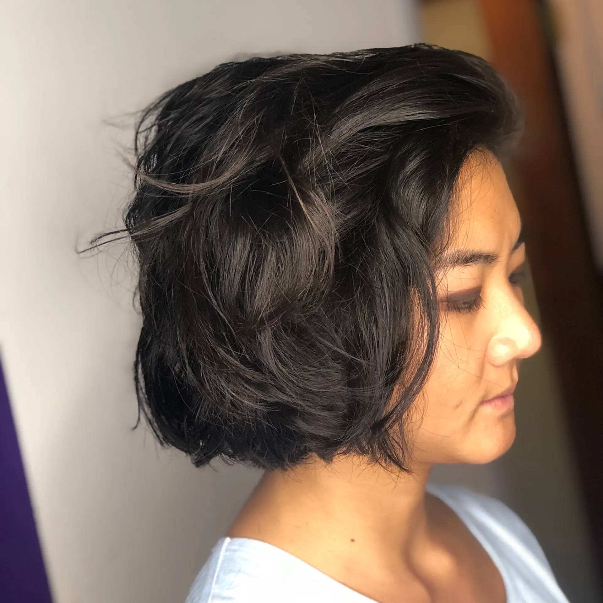 A textured chin-length bob styled with soft, piecey waves and natural volume. 1