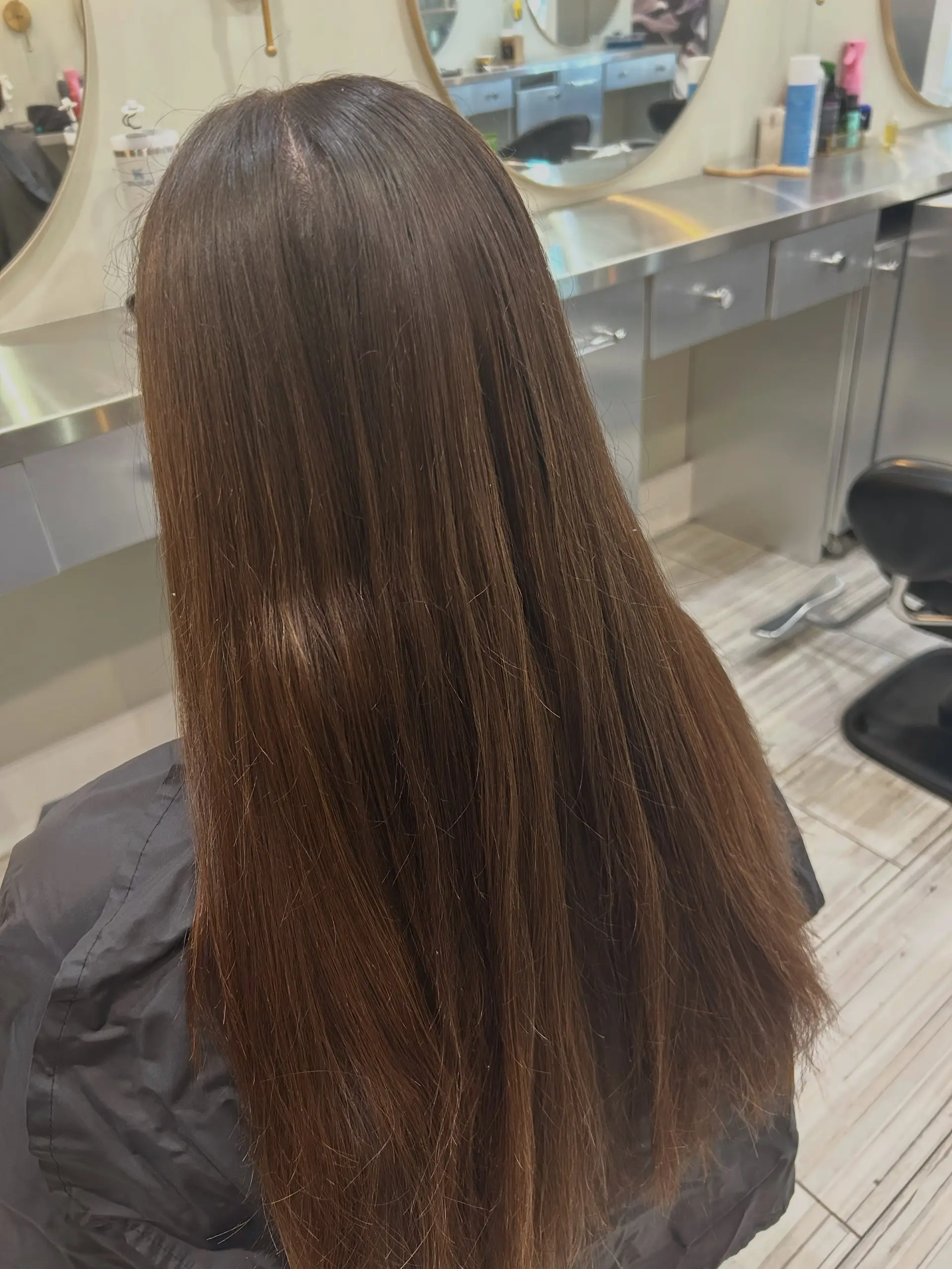 Long, straight brunette hair featuring subtle, dimensional balayage throughout for a soft, lived-in finish. 1