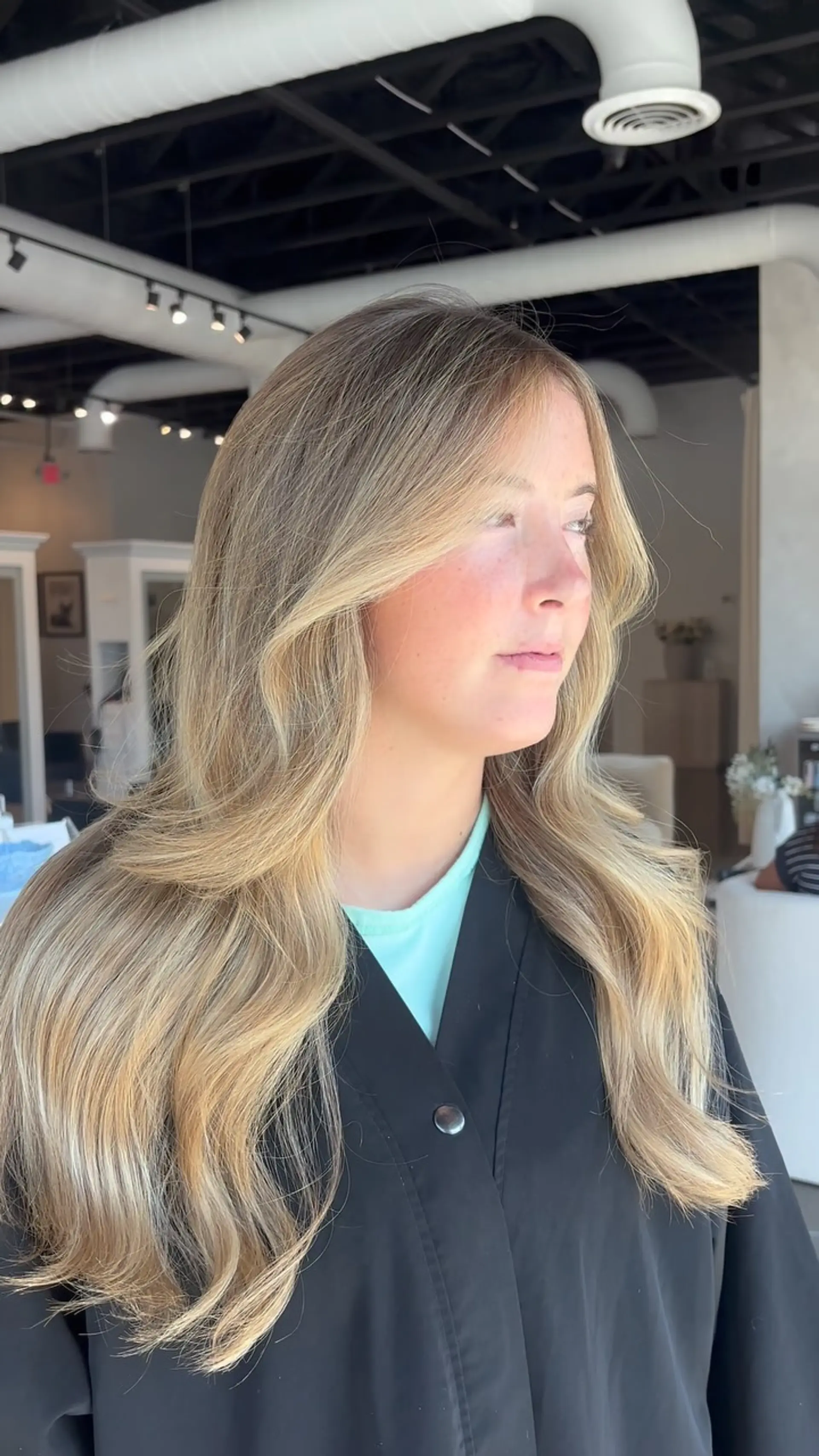 Long golden blonde hair styled in a voluminous blowout with sweeping face-framing layers. 1