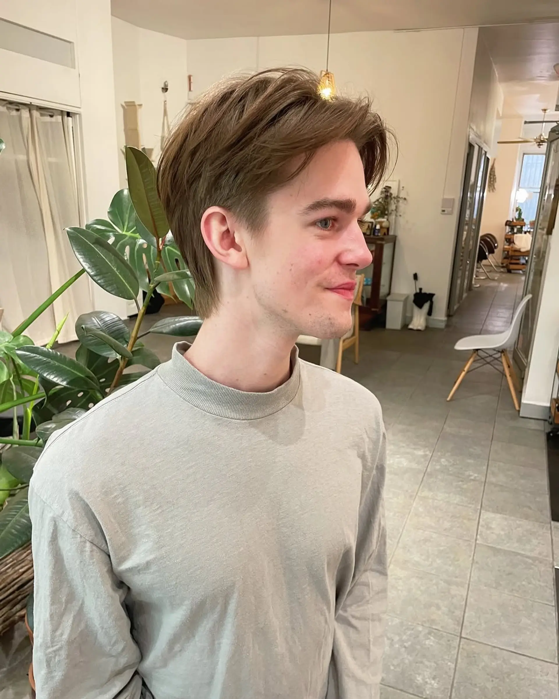 A medium-length, wavy hairstyle featuring a middle part and curtained effect. 2