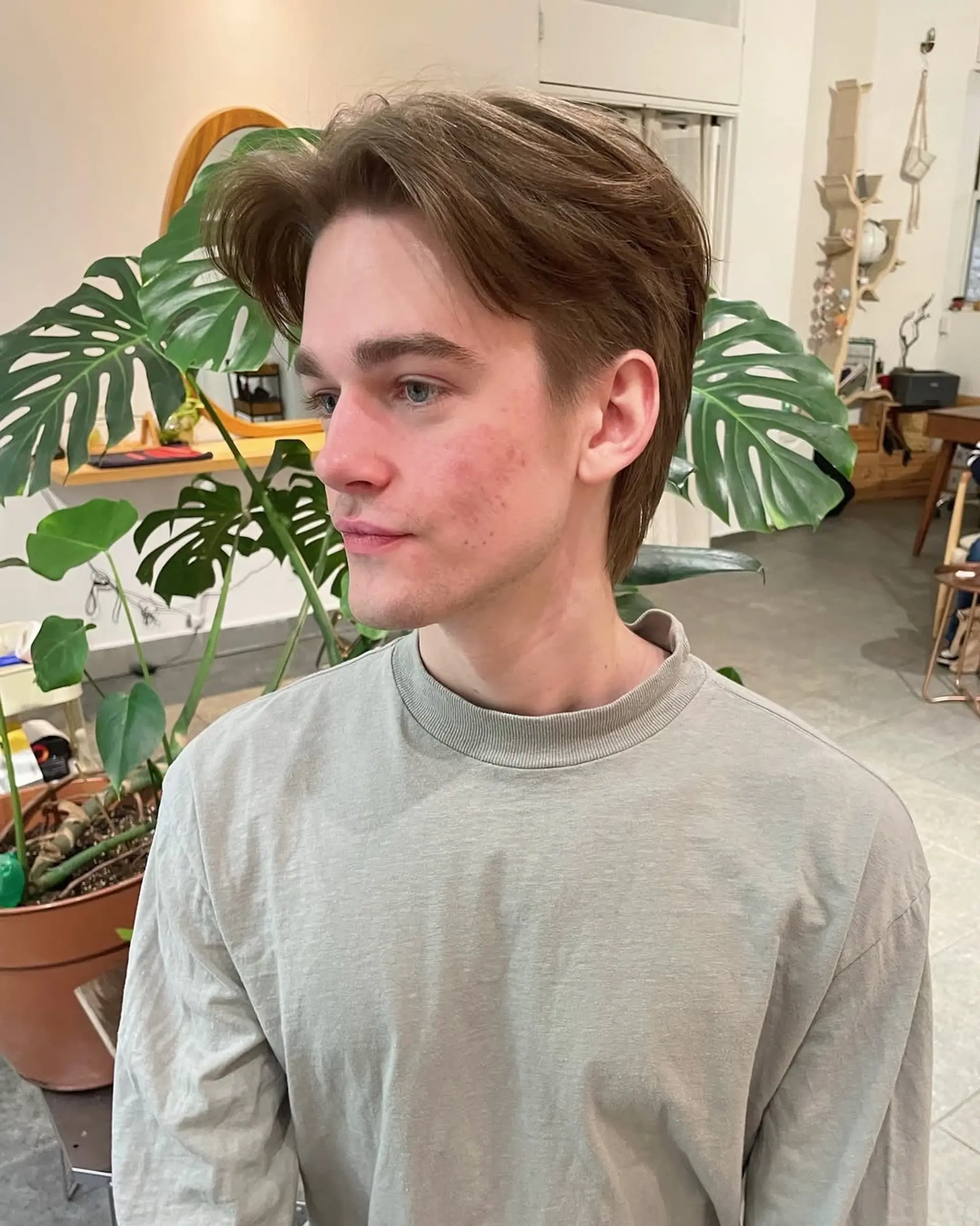 A medium-length, wavy hairstyle featuring a middle part and curtained effect. 3