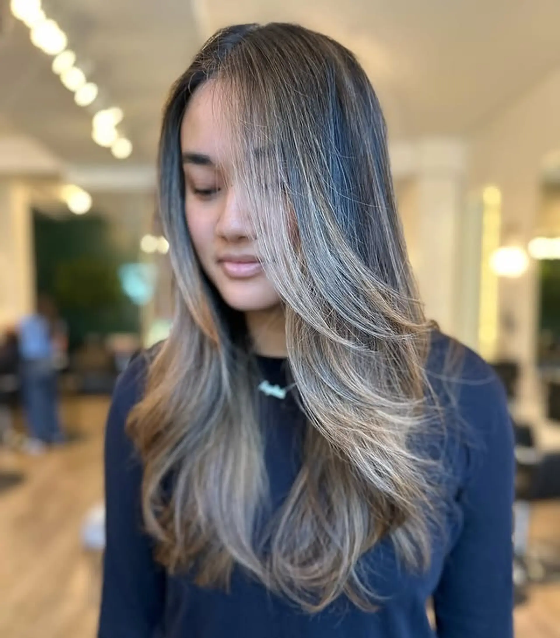 A long, straight hairstyle with face-framing layers and a soft balayage. 1