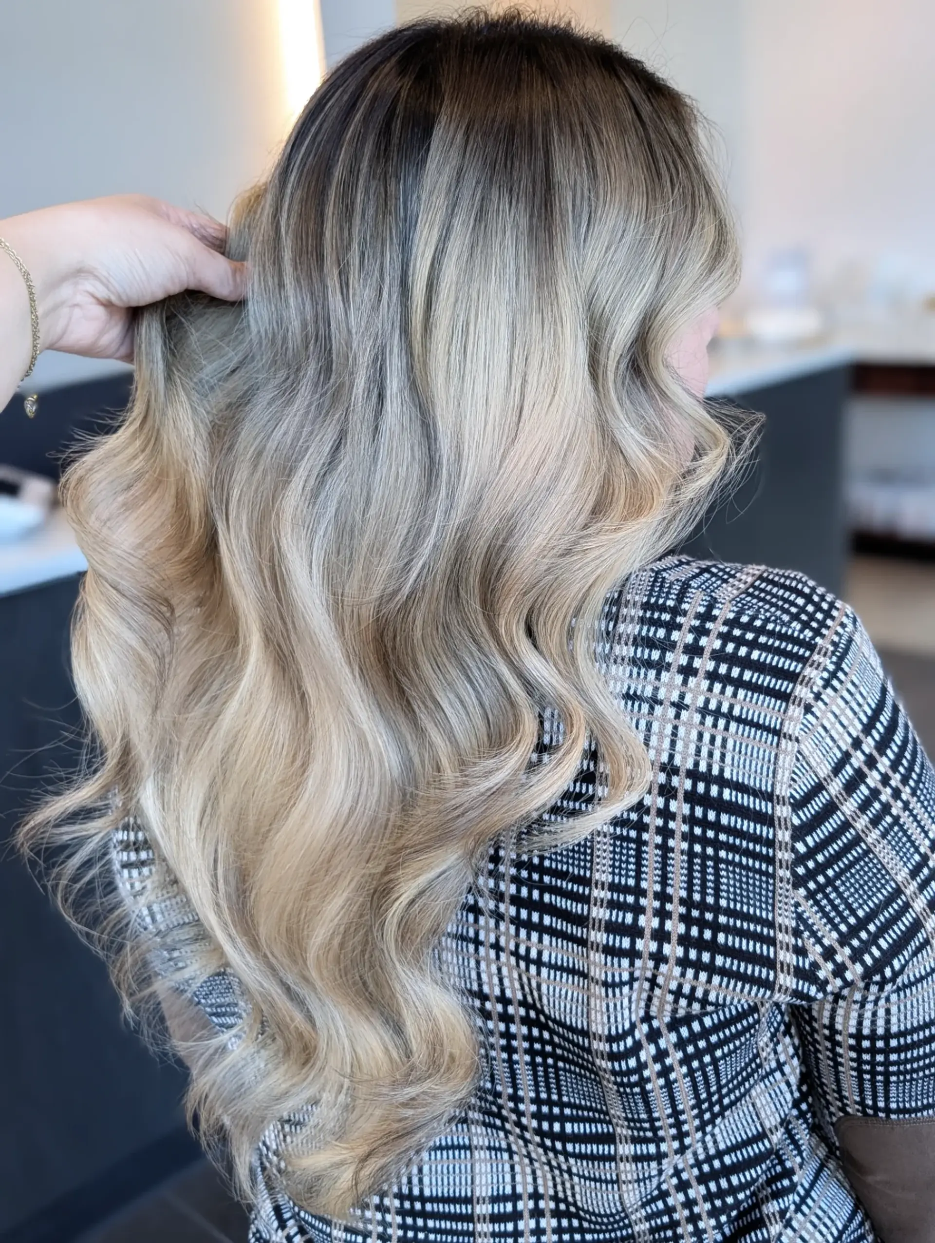 Long ash blonde foilayage with a blended shadow root, styled into glossy, loose waves. 1