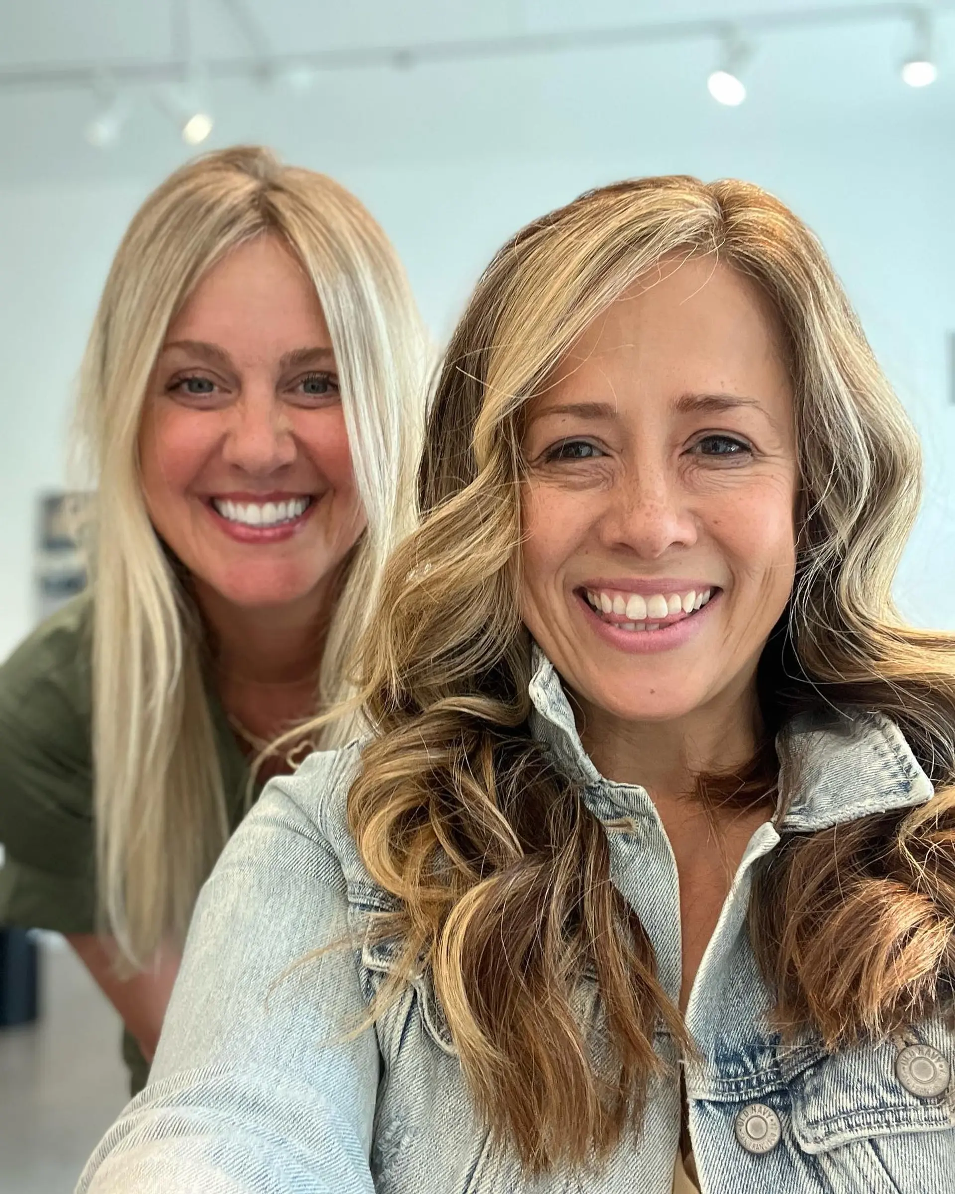 Medium-length dimensional blonde hair styled in soft, loose waves with a natural root blend. 1