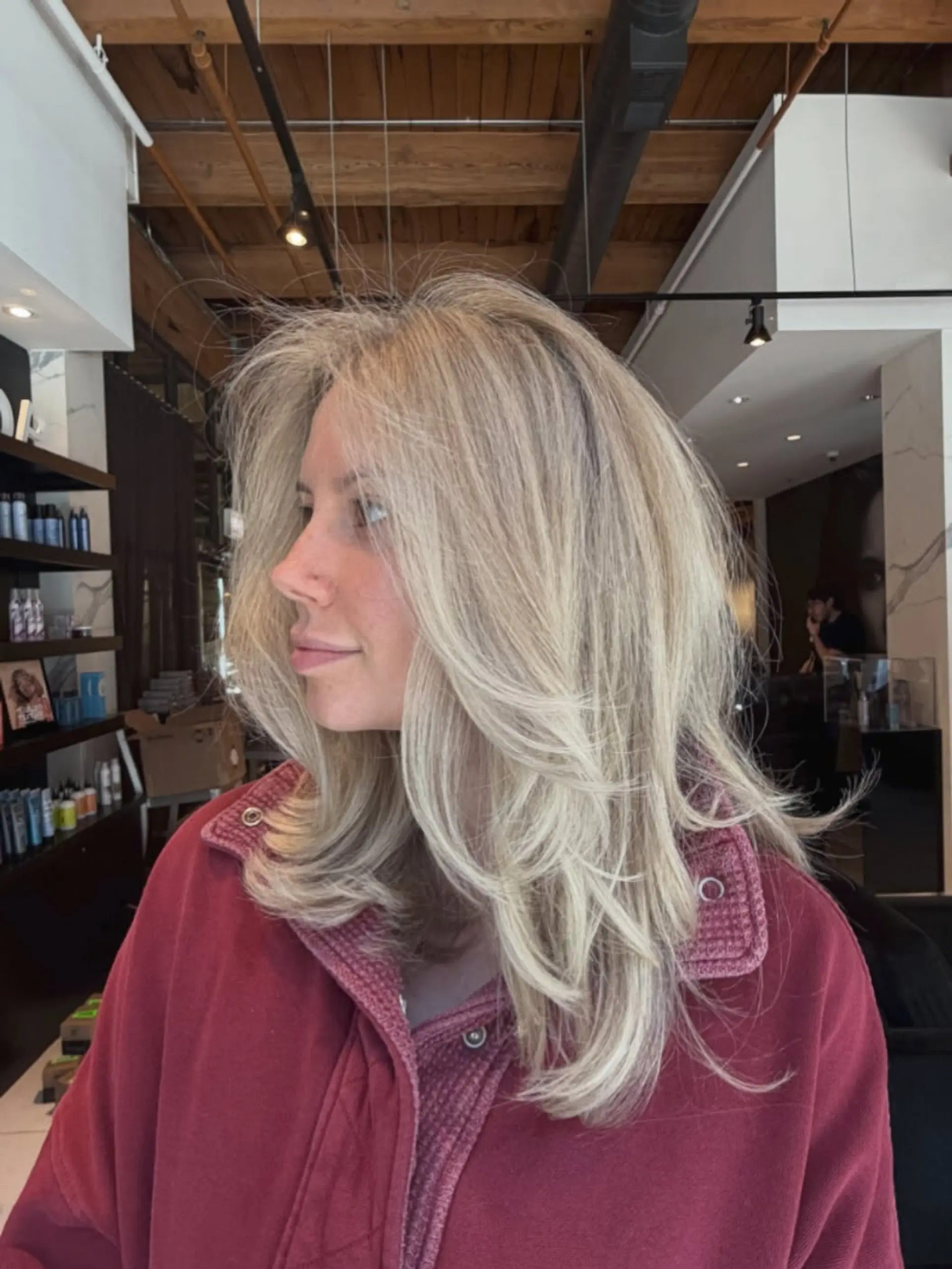 Dimensional icy blonde hair cut into soft face-framing layers and finished with a voluminous blowout. 1