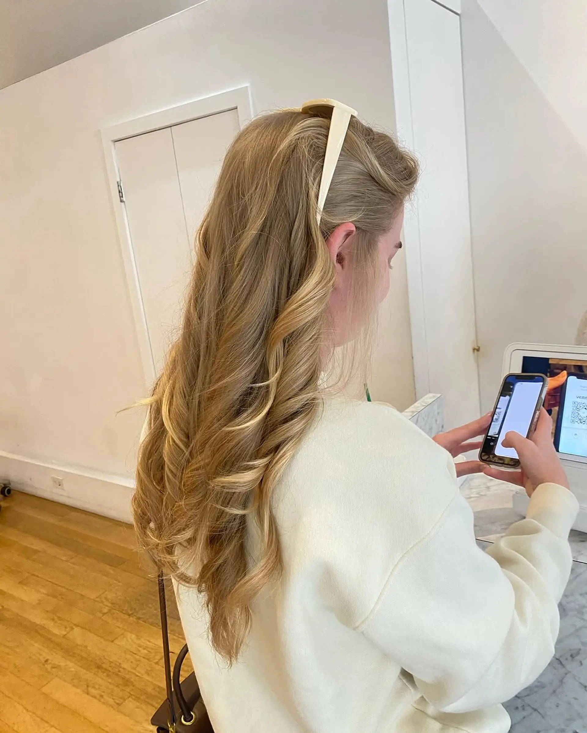 A long, wavy hairstyle with defined curls at the ends, worn in a half up style. 1