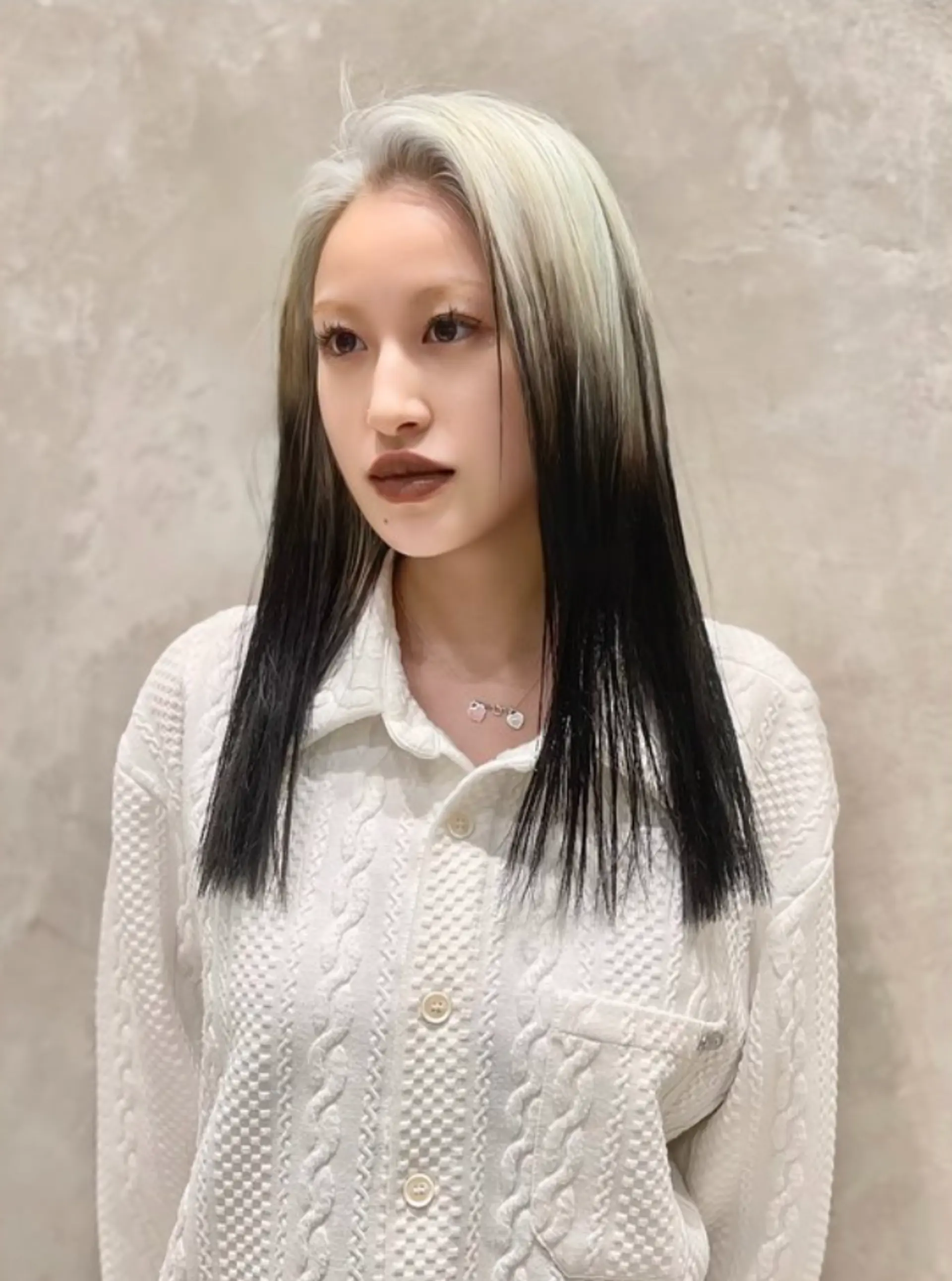 Straight, long hair with a platinum blonde top section transitioning into black towards the ends, parted in the middle with a sleek and smooth texture.

(NonstopStyle: by Hiro) 1