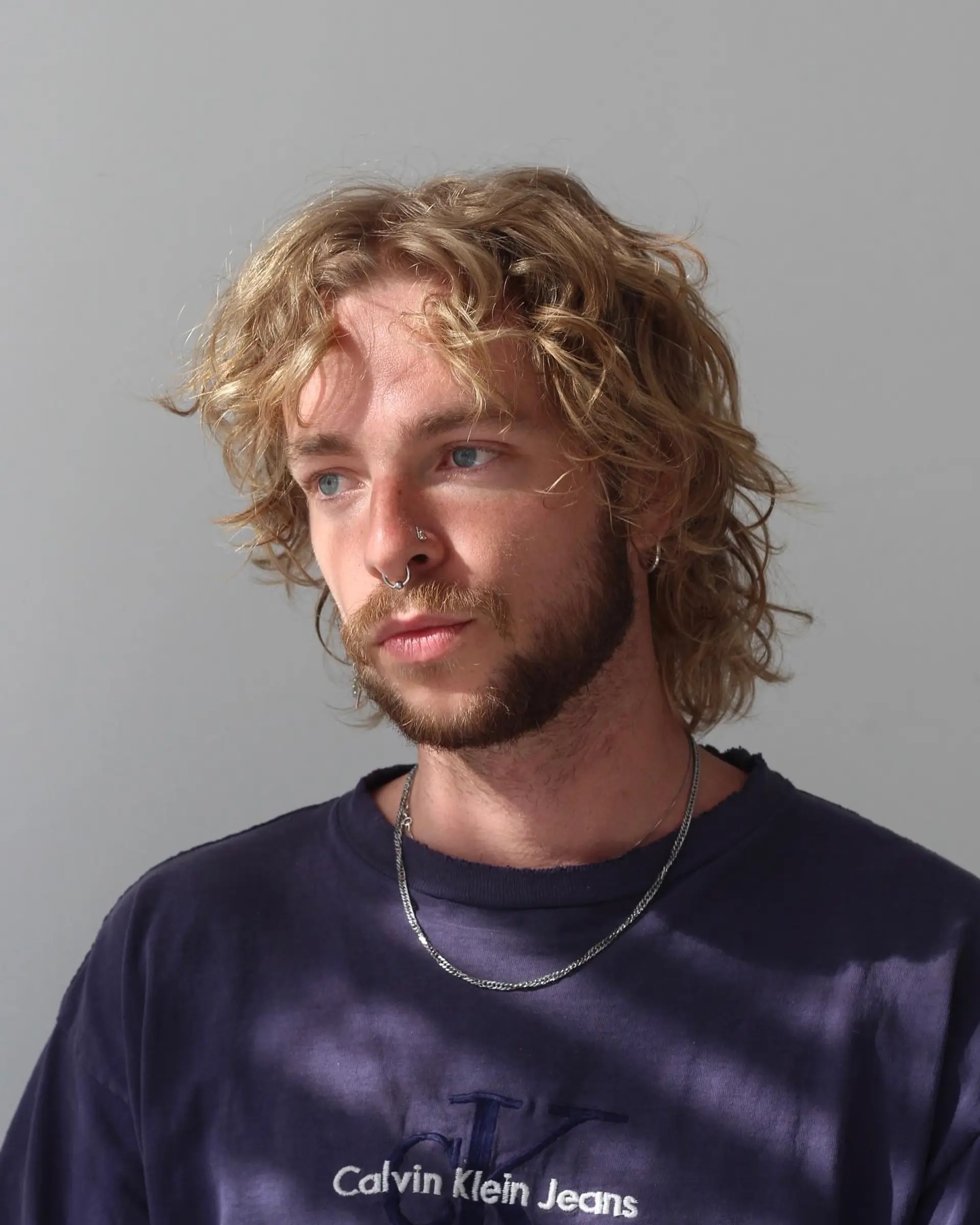 Medium-length tousled cut with natural wavy-curly texture and soft, face-framing layers. 1
