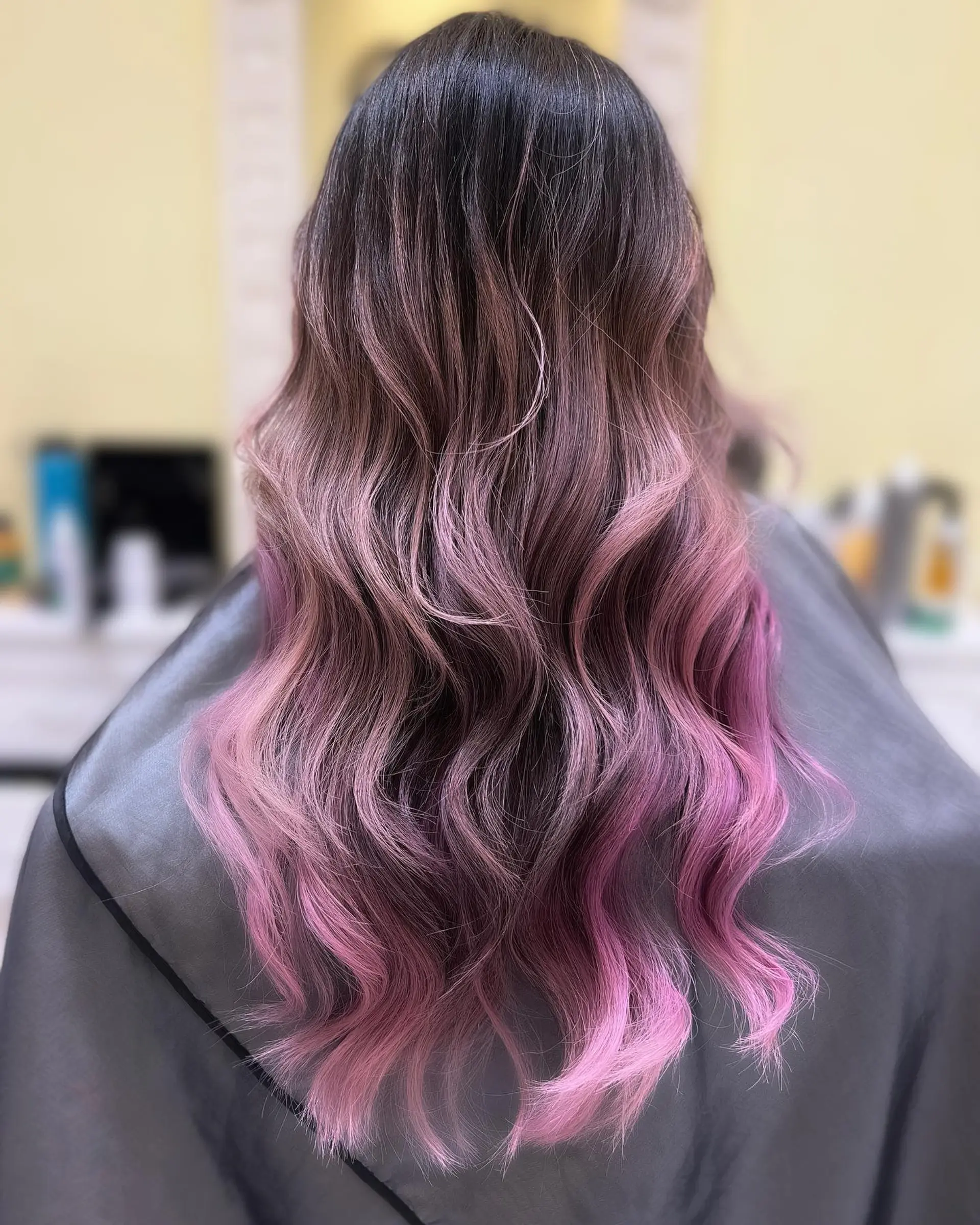 Long wavy hairstyle with a dark brown to pink ombre effect. 1